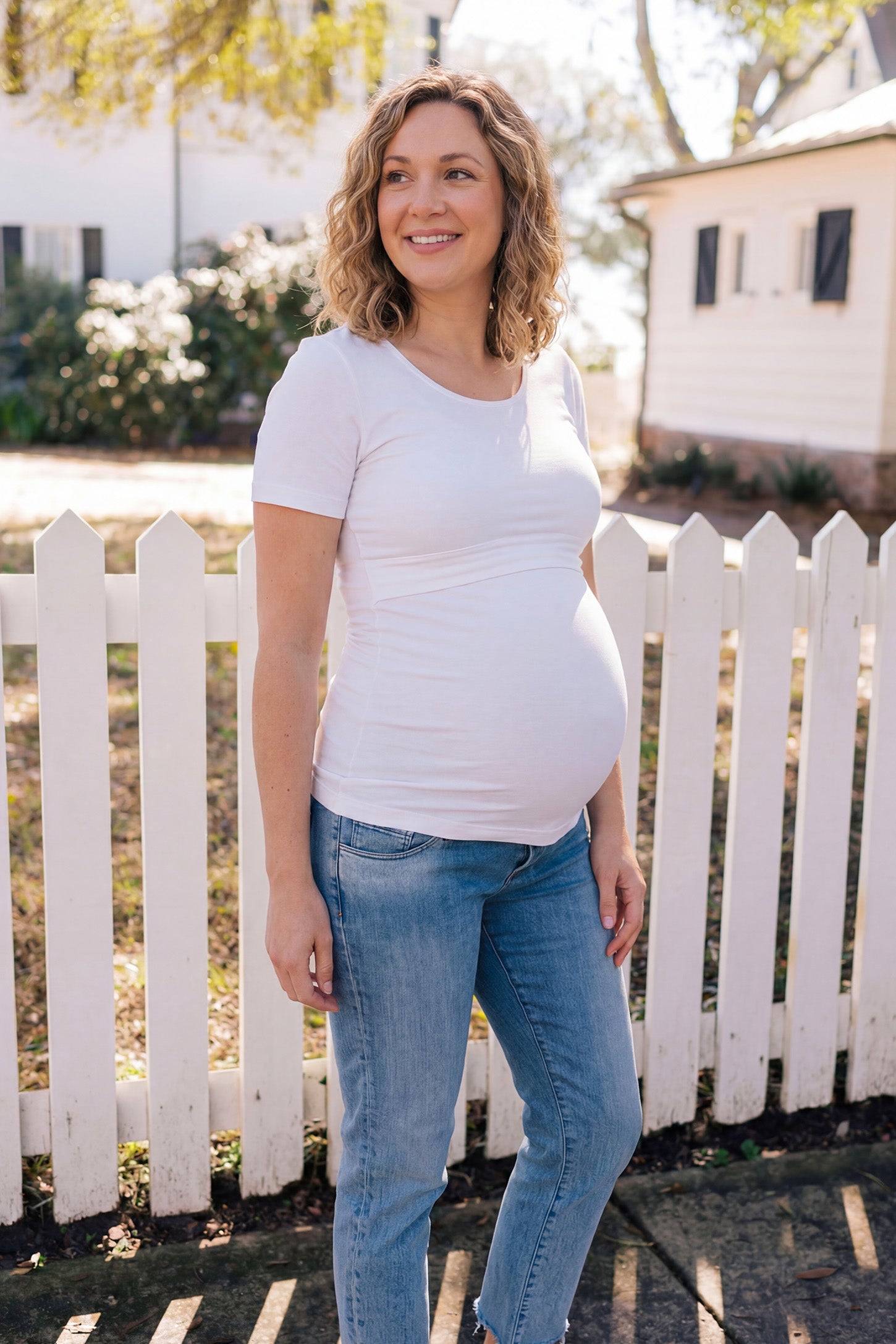Basic Crew Neck Maternity & Nursing T-Shirt in White featuring a stretch-fit round neck design on a pregnant model, ugc view.