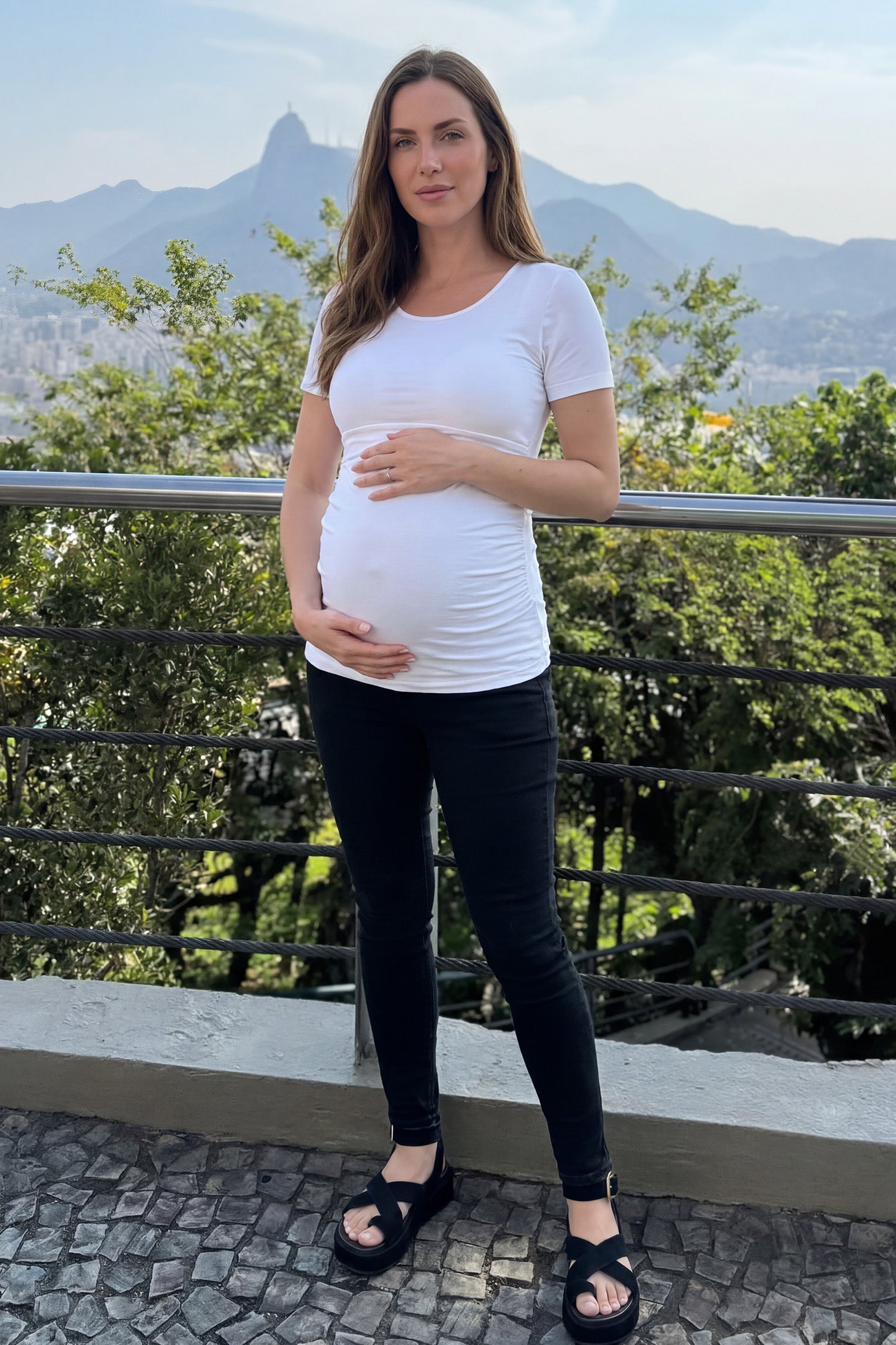Basic Crew Neck Maternity & Nursing T-Shirt Basic Crew Neck Maternity & Nursing T-Shirt in White featuring a stretch-fit round neck design on a pregnant model, ugc view.