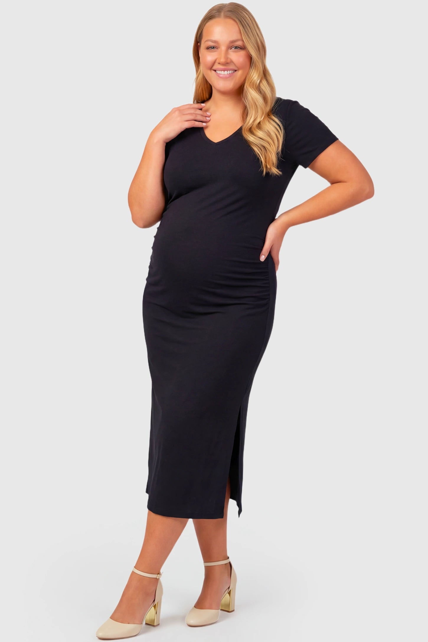 Casual V-Neck Short Sleeve Maternity Midi Dress Casual V-Neck Short Sleeve Maternity Midi Dress in black featuring a relaxed straight fit and side slit on a plus size pregnant model.