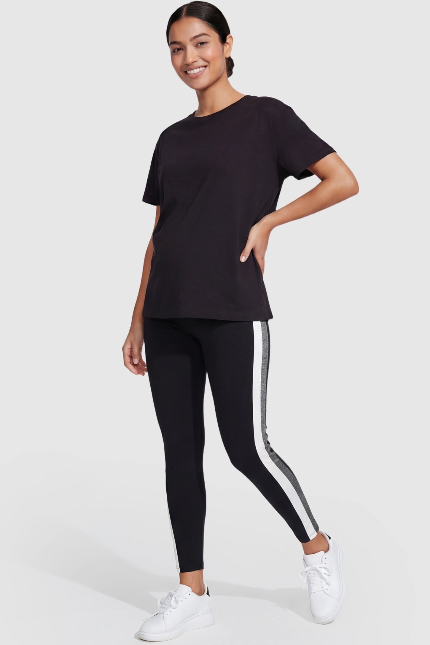 Stretch Waist Panel Side-Stripe Maternity Leggings Stretch waist panel side-stripe maternity leggings in black with bold side stripe detail, front view on postpartum model
