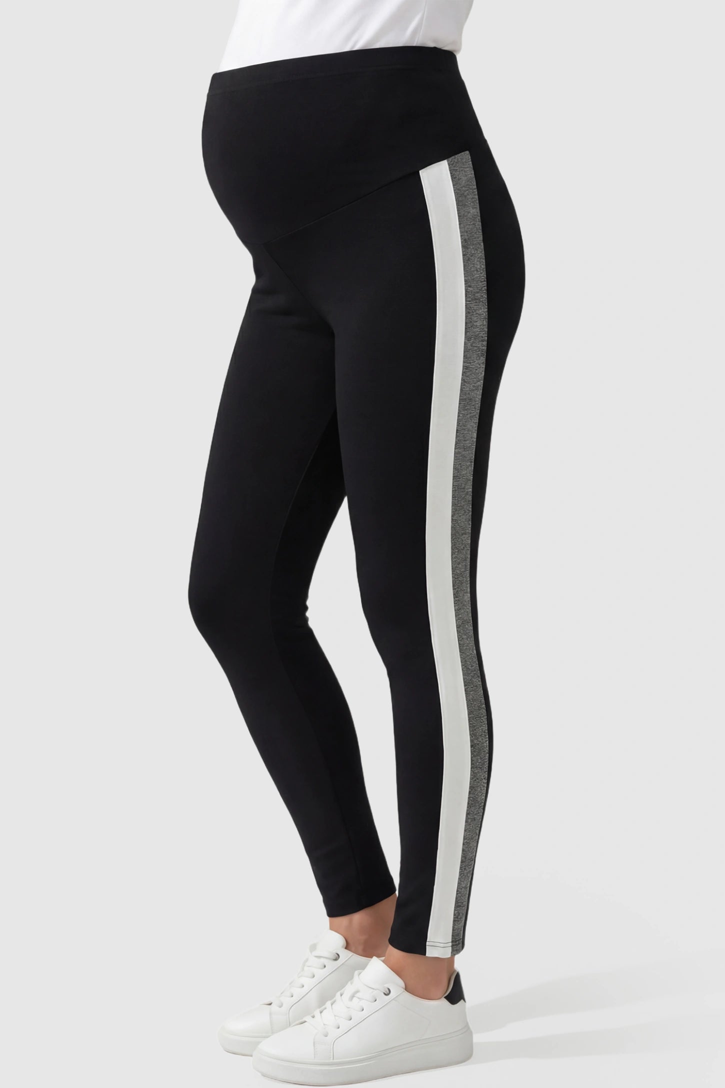 Stretch Waist Panel Side-Stripe Maternity Leggings Stretch waist panel side-stripe maternity leggings in black with bold side stripe detail, side view on pregnant model