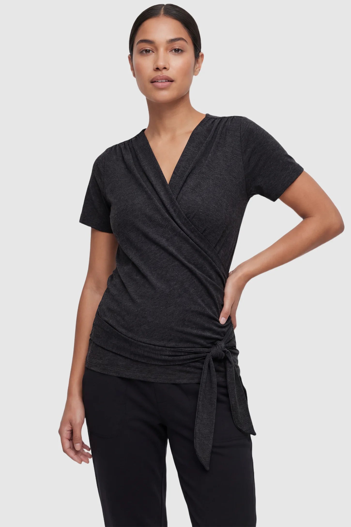 3 in 1 Skin to Skin Wrap Nursing Top Skin to Skin Wrap Nursing Top in black featuring soft wrap-front design and short sleeves on non pregnant model.