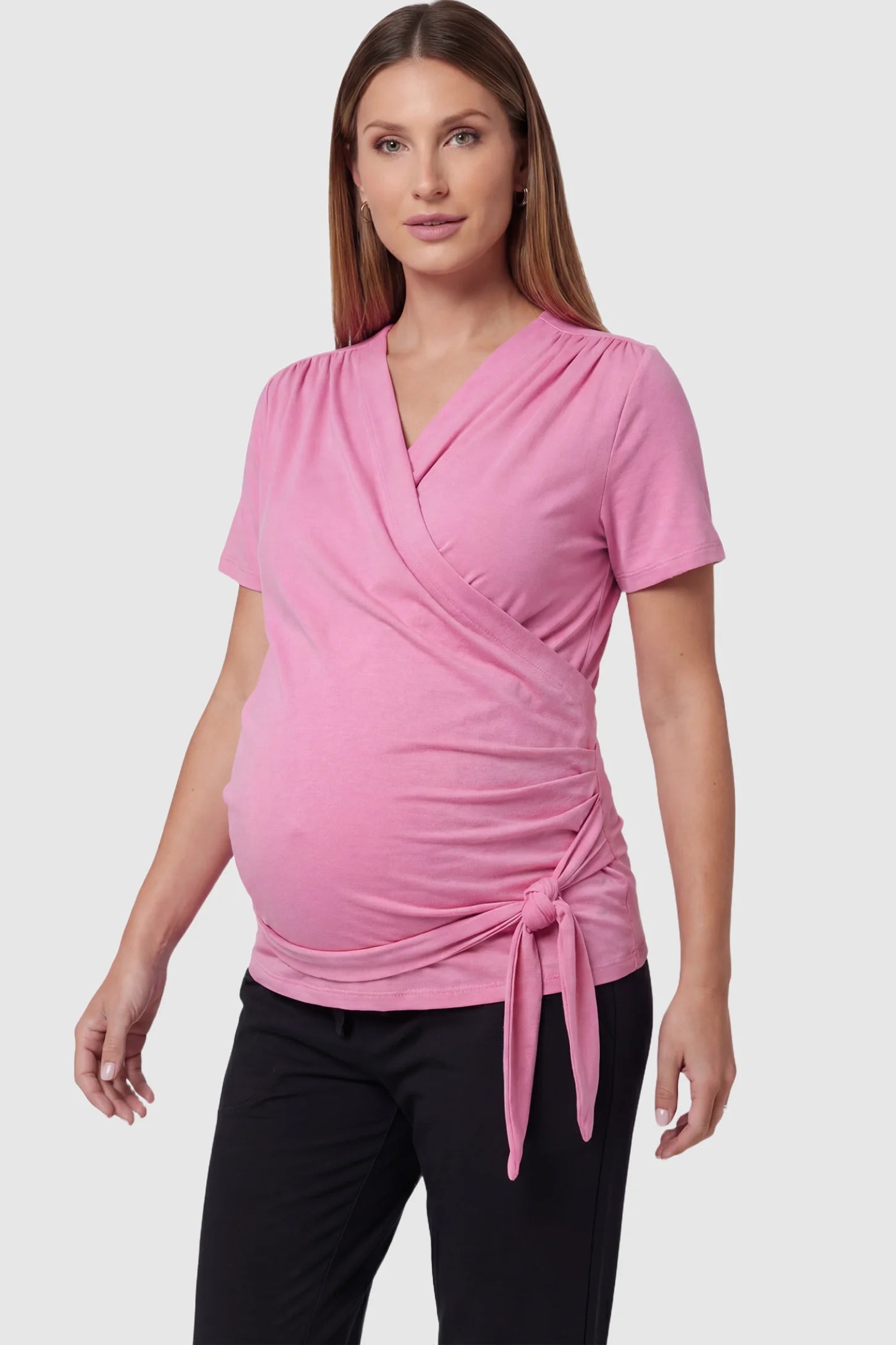 3 in 1 Skin to Skin Wrap Nursing Top Skin to Skin Wrap Nursing Top in pink featuring soft wrap-front design and short sleeves on pregnant model, front view.
