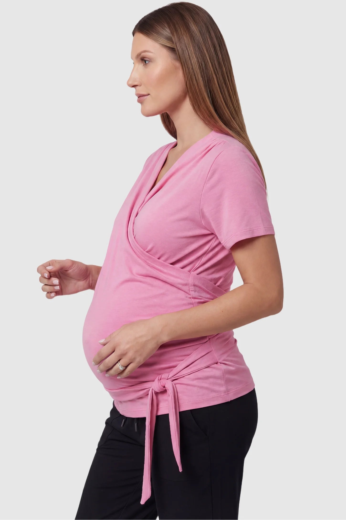 3 in 1 Skin to Skin Wrap Nursing Top Skin to Skin Wrap Nursing Top in pink featuring soft wrap-front design and short sleeves on pregnant model, side view.