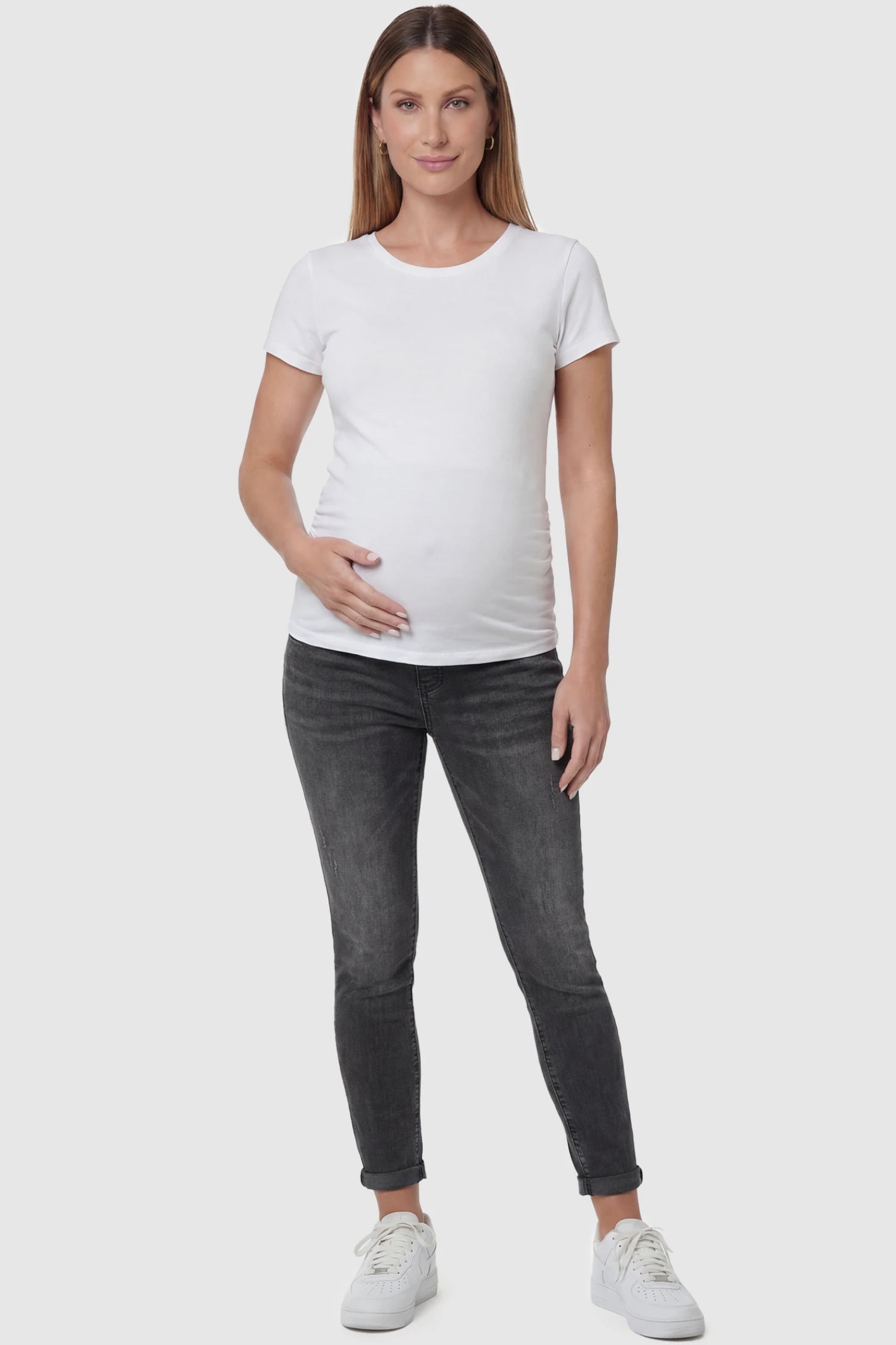 Cuffed Hem Skinny Maternity Jeans Cuffed Hem Skinny Maternity Jeans in black featuring full belly panel and ankle-length cuffed hem on front  view pregnant model.