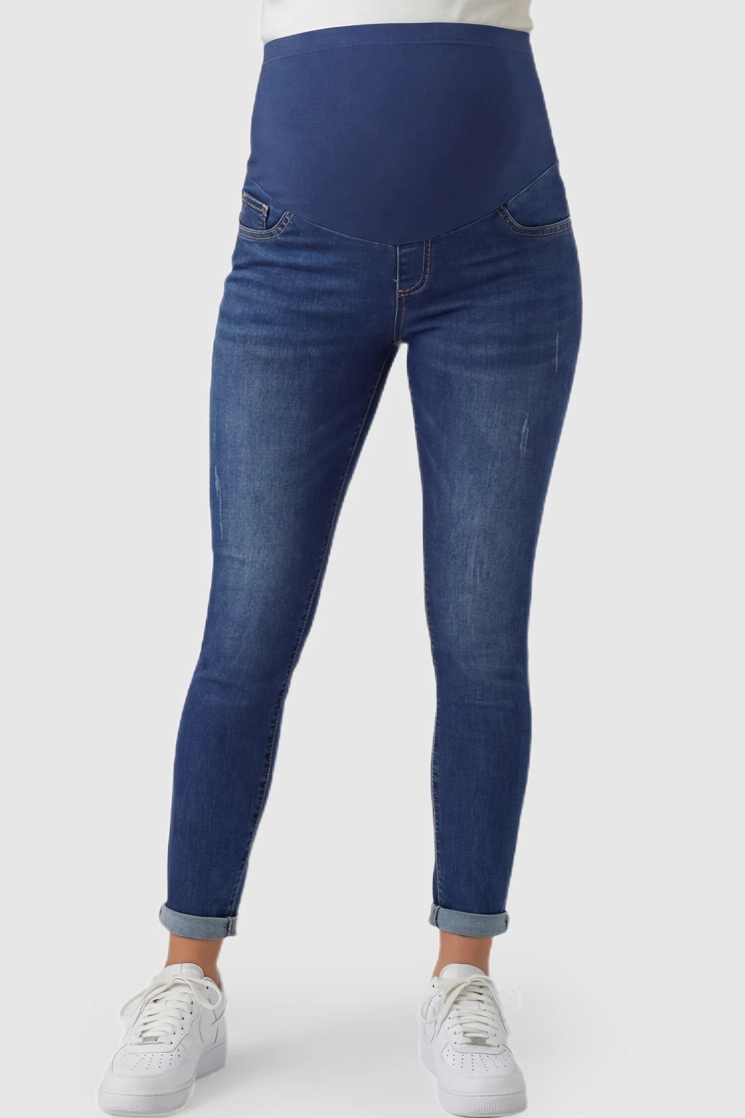 Cuffed Hem Skinny Maternity Jeans Cuffed Hem Skinny Maternity Jeans in dark blue featuring full belly panel and ankle-length cuffed hem on pregnant model.