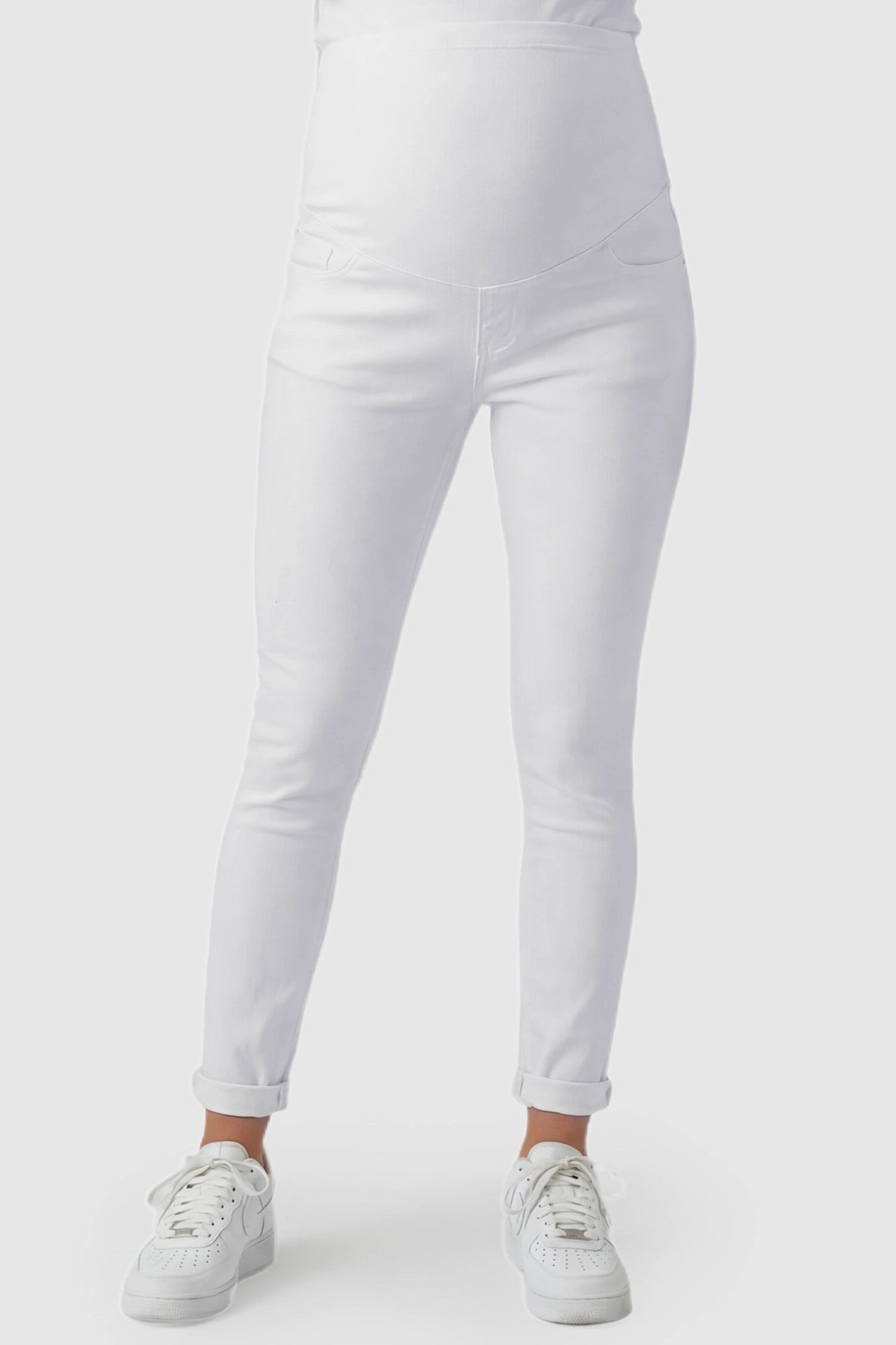 Cuffed Hem Skinny Maternity Jeans in White featuring full belly panel and ankle-length cuffed hem on pregnant model.