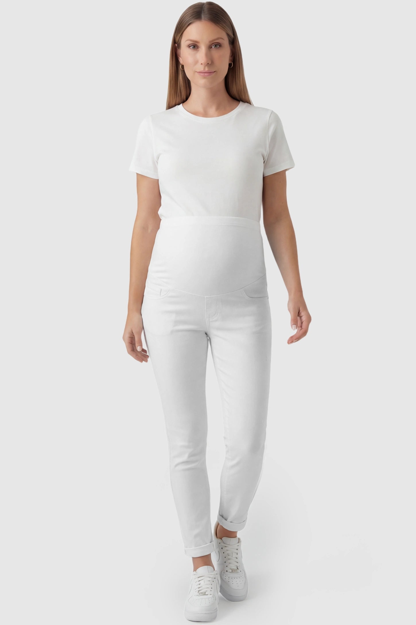 Cuffed Hem Skinny Maternity Jeans in White featuring full belly panel and ankle-length cuffed hem on pregnant model.