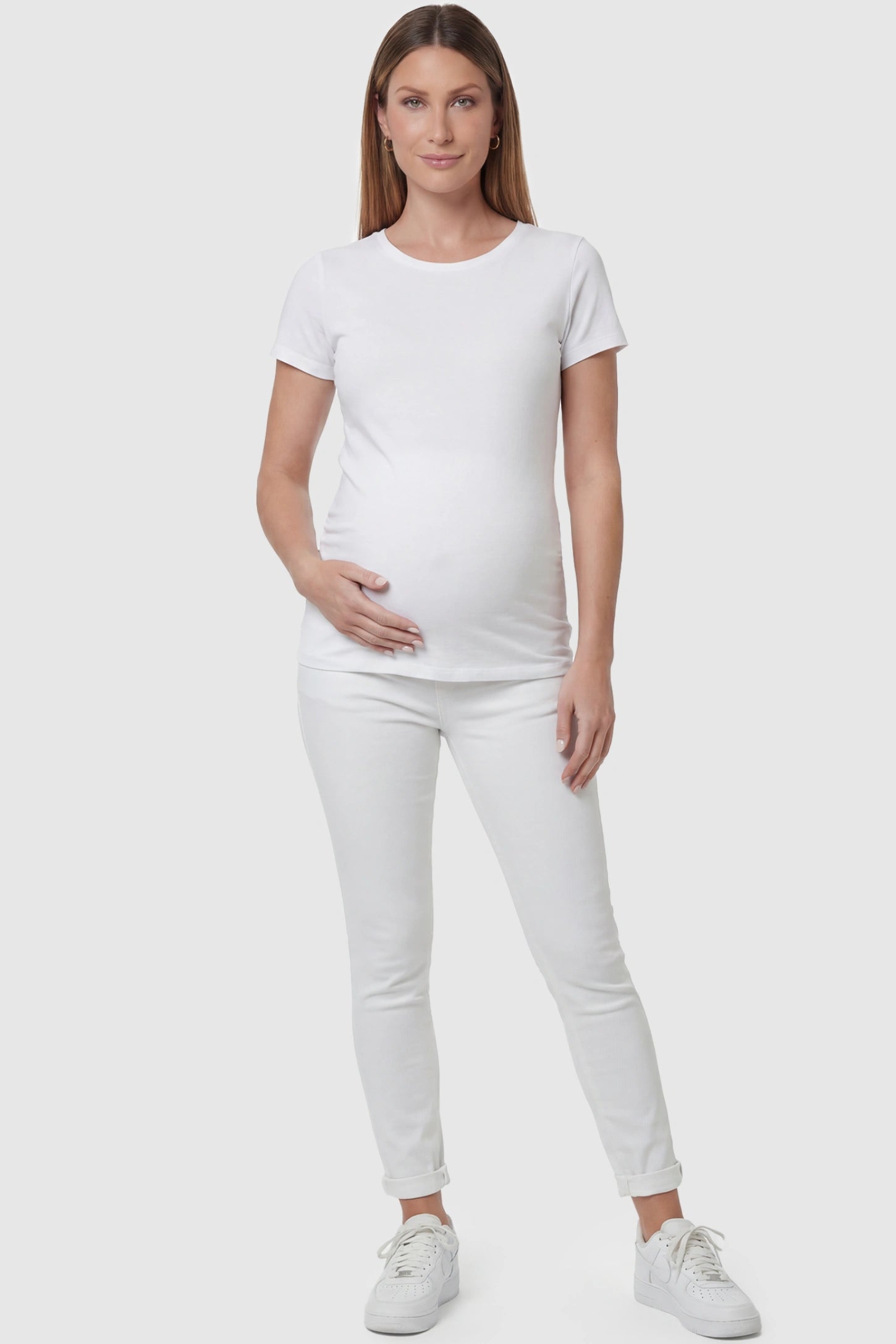 Cuffed Hem Skinny Maternity Jeans Cuffed Hem Skinny Maternity Jeans in White featuring full belly panel and ankle-length cuffed hem on front  view pregnant model.