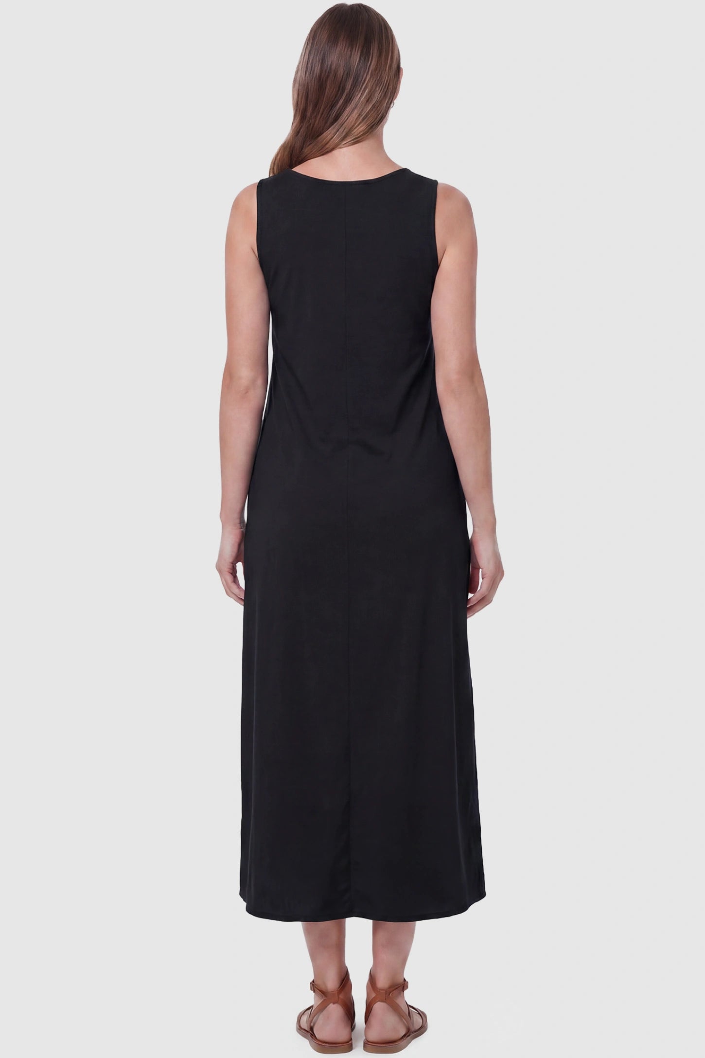 Sleeveless Pocketed Longline Hem Maternity Midi Dress Sleeveless pocketed longline hem maternity midi dress in black with sleeveless design and longline hem, back view on pregnant model
