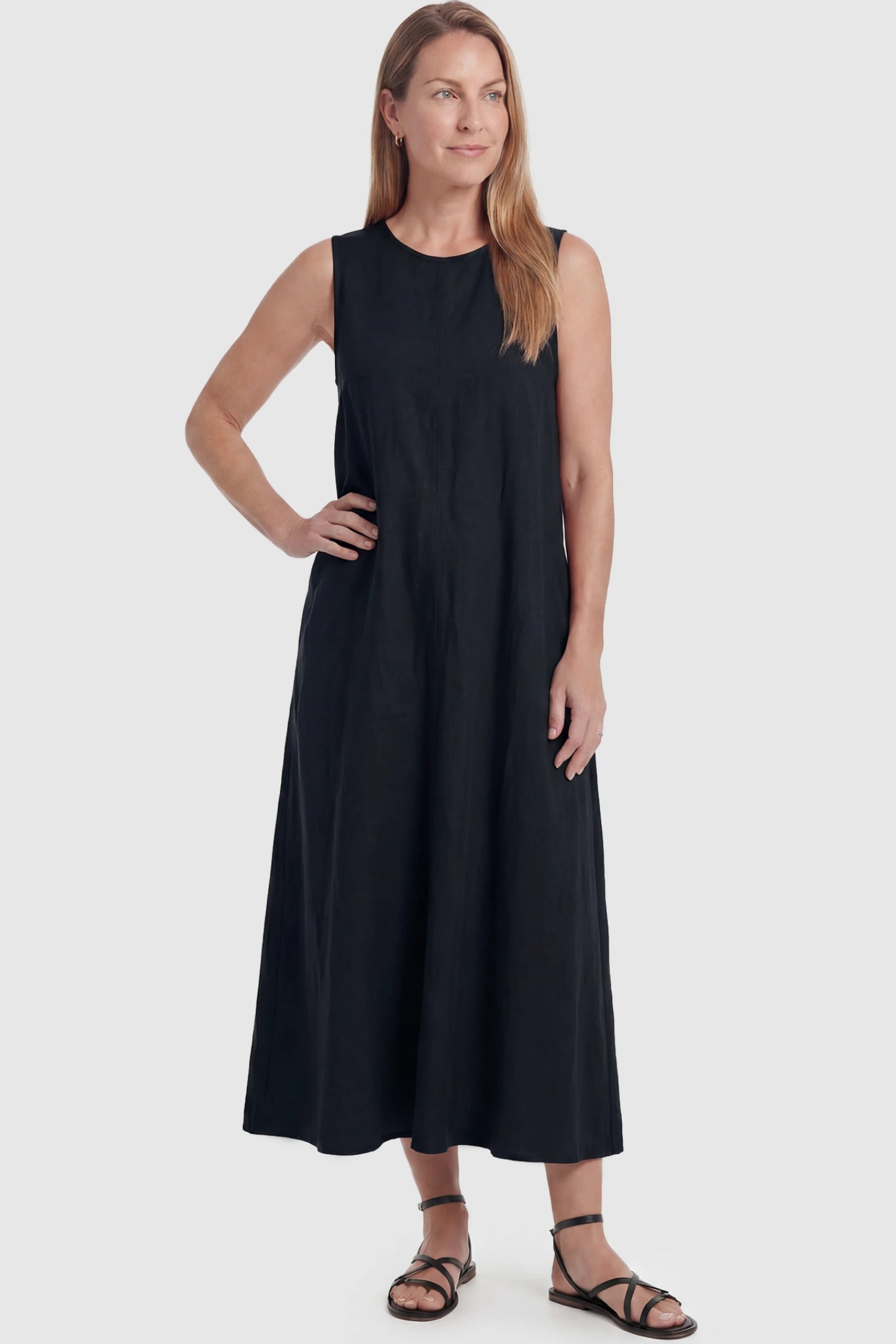 Sleeveless Pocketed Longline Hem Maternity Midi Dress Sleeveless pocketed longline hem maternity midi dress in black with sleeveless design and longline hem, front view on postpartum model