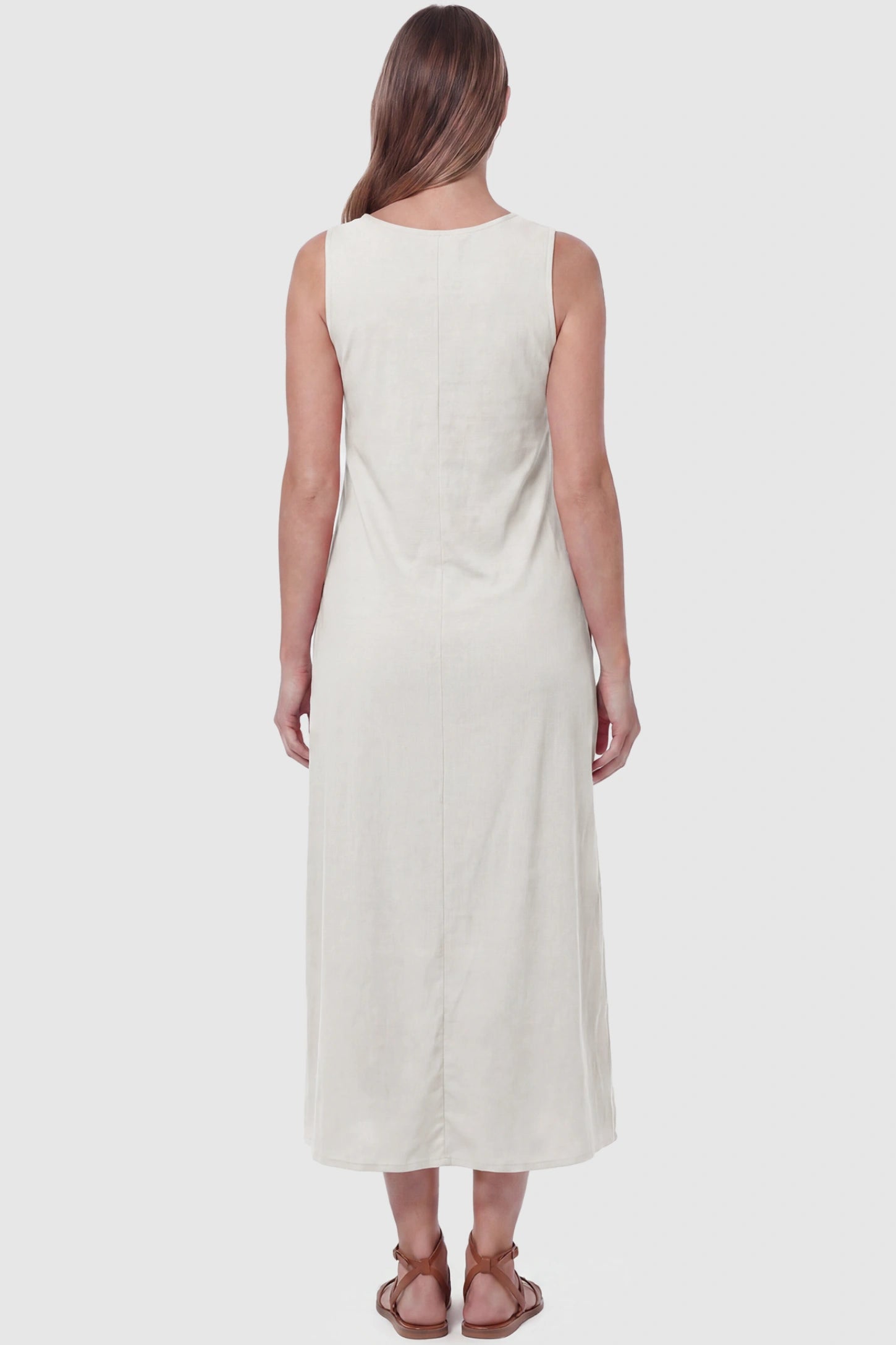 Sleeveless Pocketed Longline Hem Maternity Midi Dress Sleeveless pocketed longline hem maternity midi dress in cream with sleeveless design and longline hem, back view on pregnant model