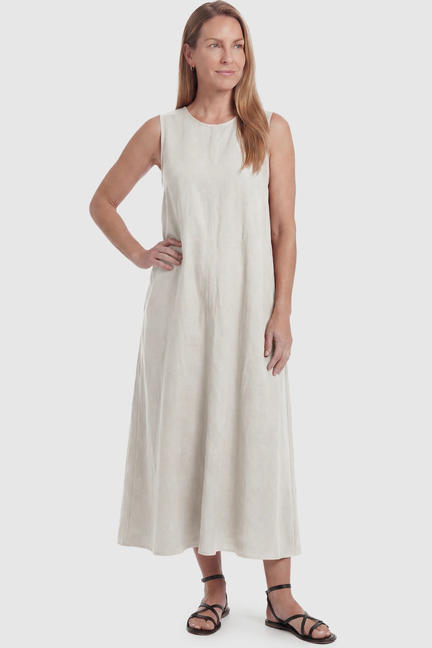 Sleeveless Pocketed Longline Hem Maternity Midi Dress Sleeveless pocketed longline hem maternity midi dress in cream with sleeveless design and longline hem, front view on postpartum model
