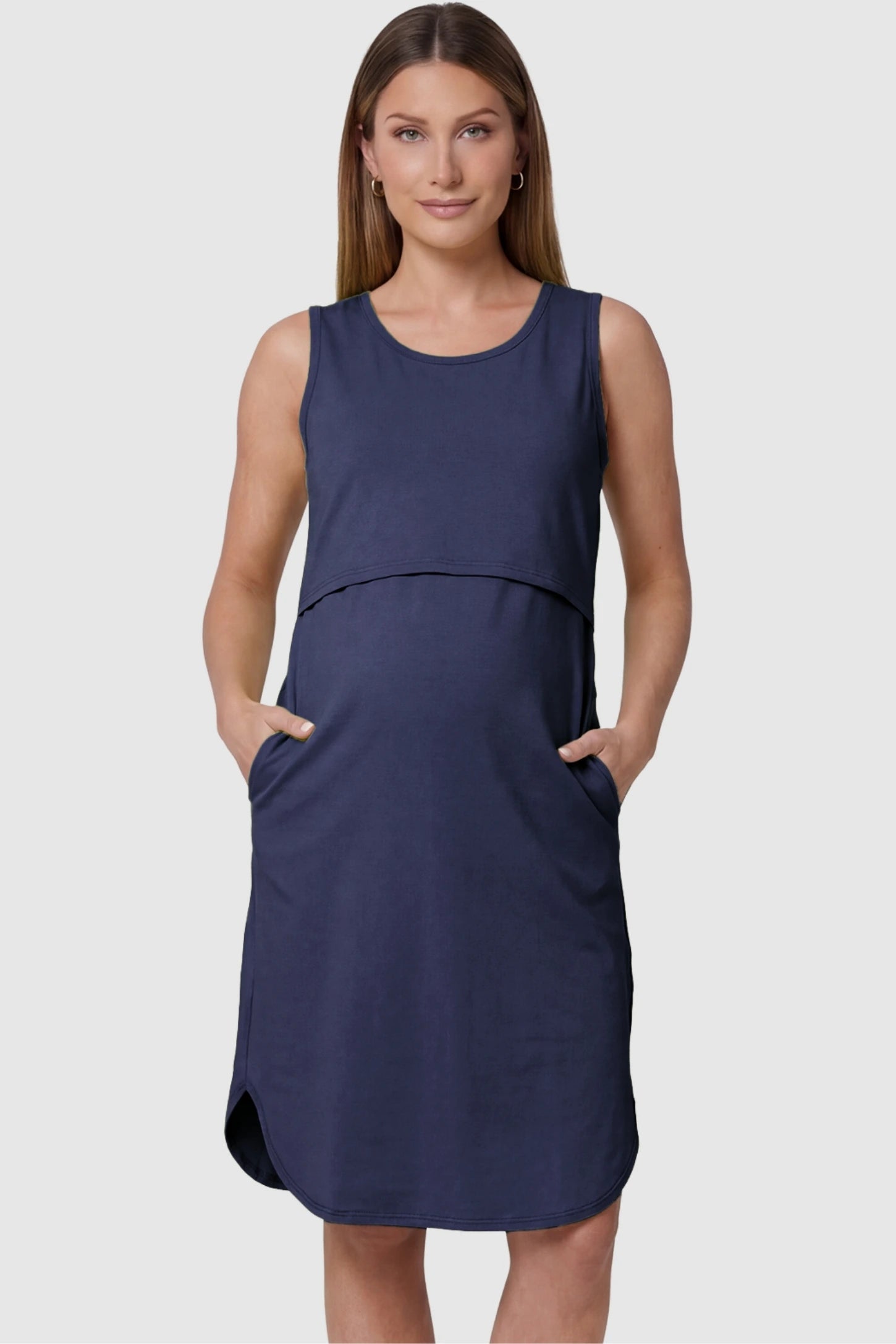 Sleeveless High-Waisted Midi Maternity & Nursing Dress Sleeveless high-waisted midi maternity and nursing dress in dark blue featuring functional side pockets in front view on a pregnant model