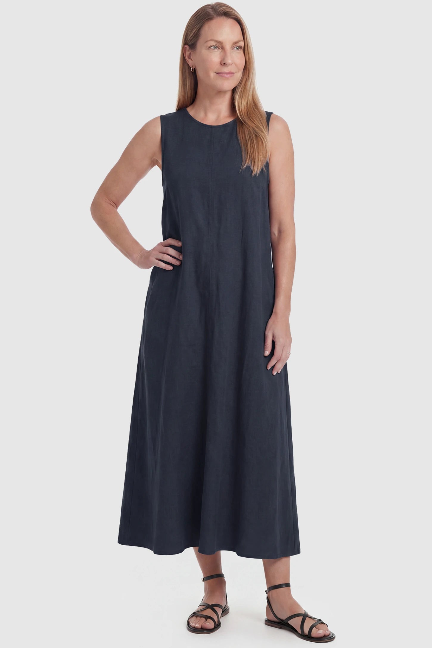Sleeveless Pocketed Longline Hem Maternity Midi Dress Sleeveless pocketed longline hem maternity midi dress in dark blue with sleeveless design and longline hem, front view on postpartum model