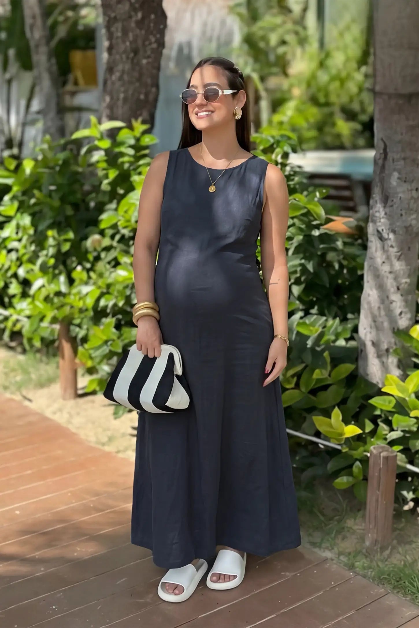 Sleeveless Pocketed Longline Hem Maternity Midi Dress Sleeveless pocketed longline hem maternity midi dress in dark blue with sleeveless design and longline hem, front view on pregnant model