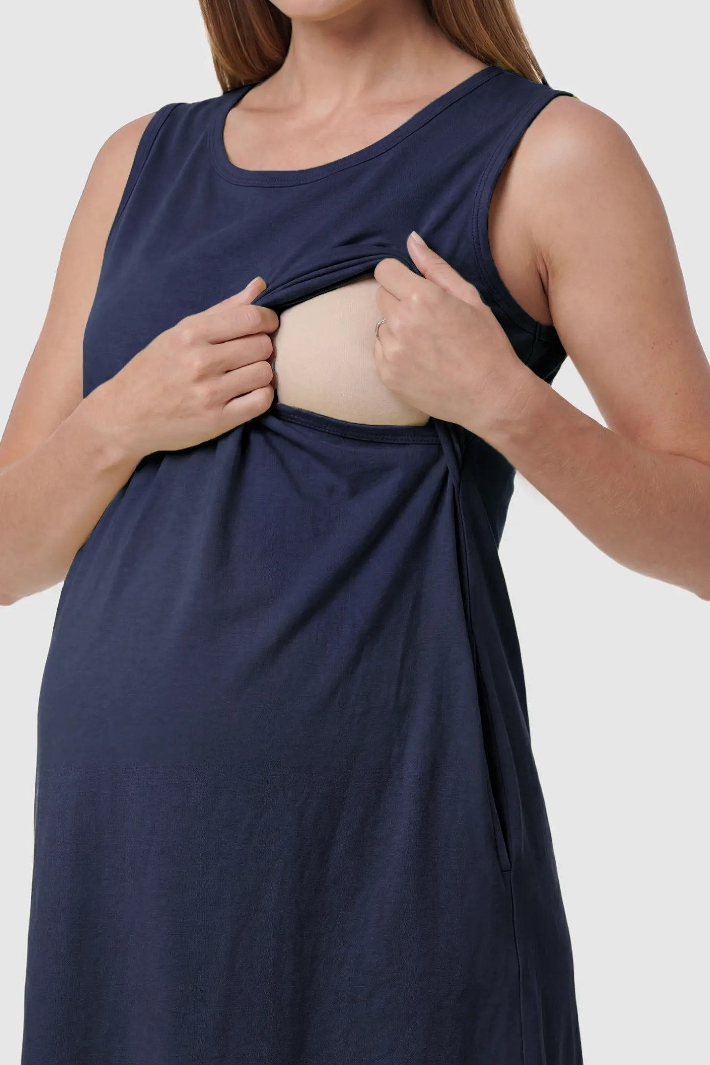 Sleeveless High-Waisted Midi Maternity & Nursing Dress Sleeveless high-waisted midi maternity and nursing dress in dark blue featuring discreet nursing access in front view on a pregnant model