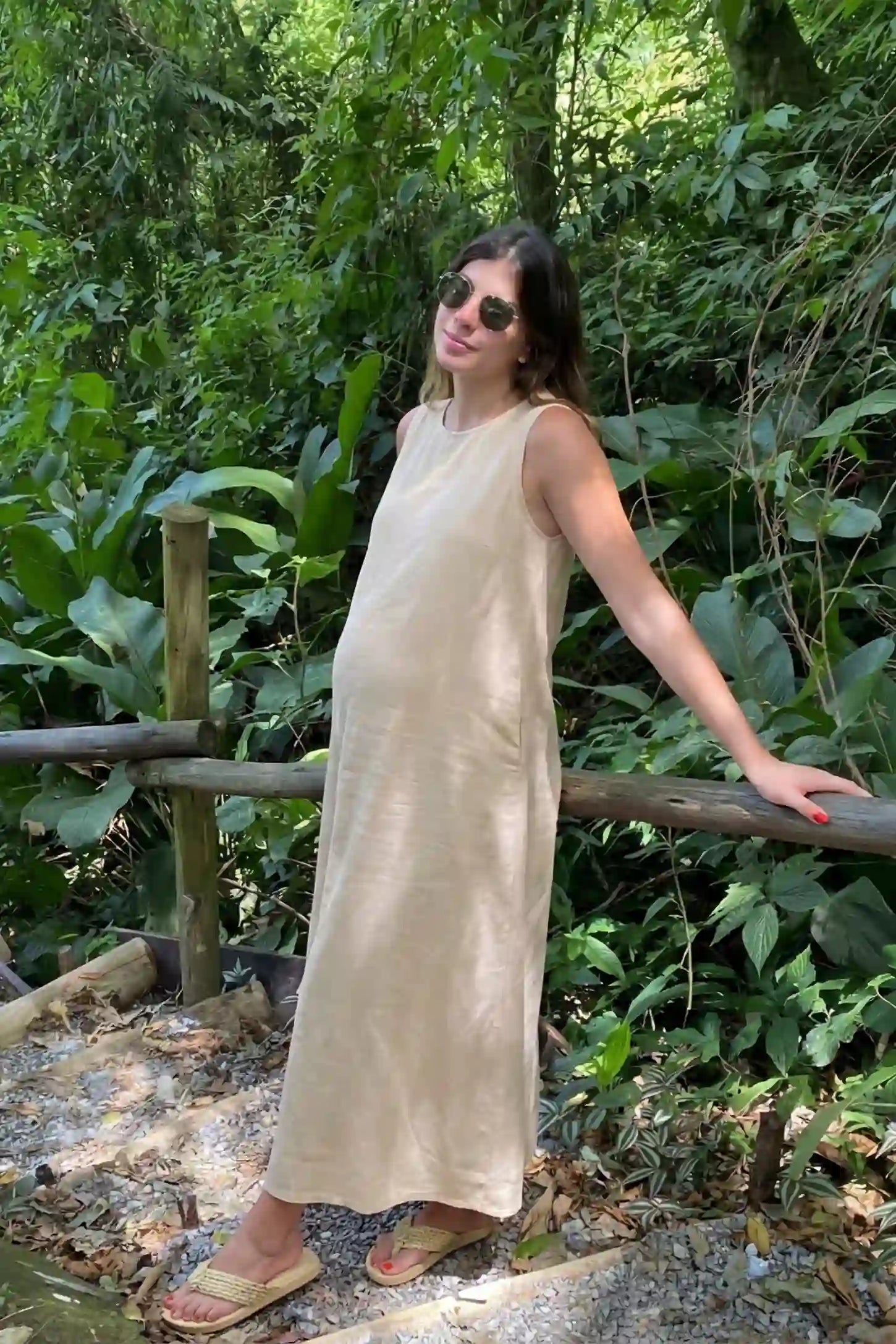 Sleeveless Pocketed Longline Hem Maternity Midi Dress Sleeveless pocketed longline hem maternity midi dress in khaki with sleeveless design and longline hem, side view on pregnant model