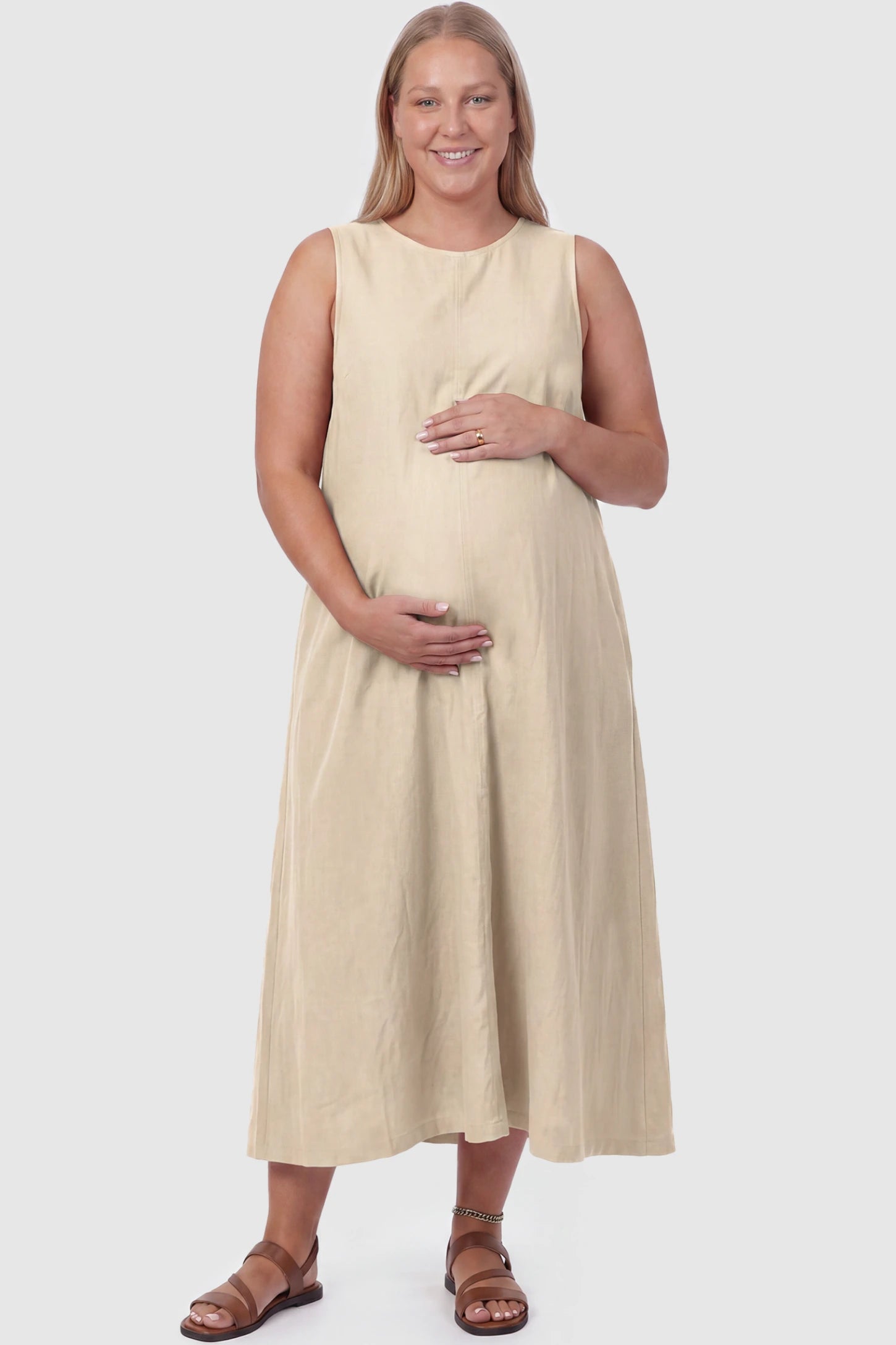 Sleeveless Pocketed Longline Hem Maternity Midi Dress Sleeveless pocketed longline hem maternity midi dress in khaki with sleeveless design and longline hem, front view on plus-size model
