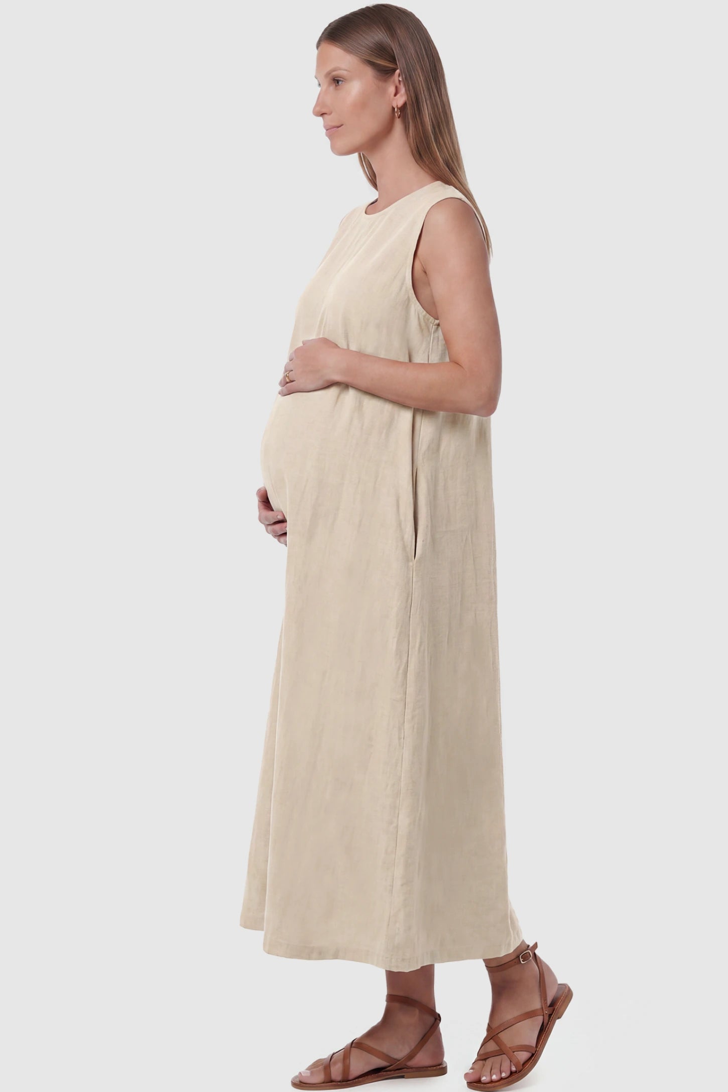 Sleeveless Pocketed Longline Hem Maternity Midi Dress Sleeveless pocketed longline hem maternity midi dress in khaki with sleeveless design and side pocket, side view on pregnant model