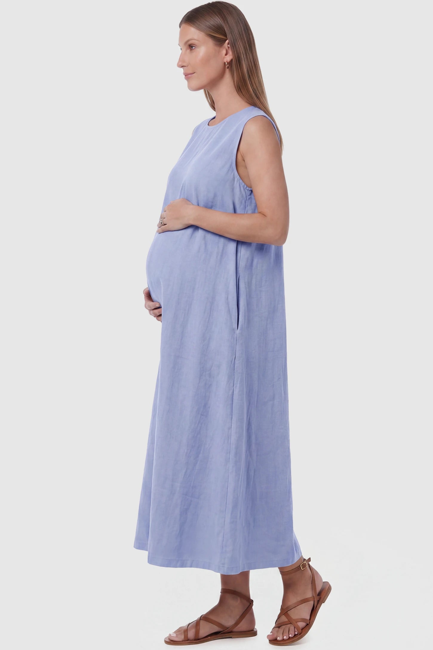 Sleeveless Pocketed Longline Hem Maternity Midi Dress Sleeveless pocketed longline hem maternity midi dress in light blue with sleeveless design and side pocket, side view on pregnant model