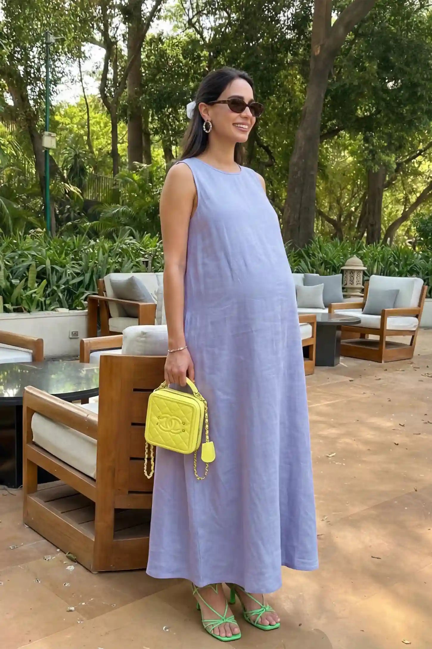 Sleeveless Pocketed Longline Hem Maternity Midi Dress Sleeveless pocketed longline hem maternity midi dress in light blue with sleeveless design and longline hem, side view on pregnant model