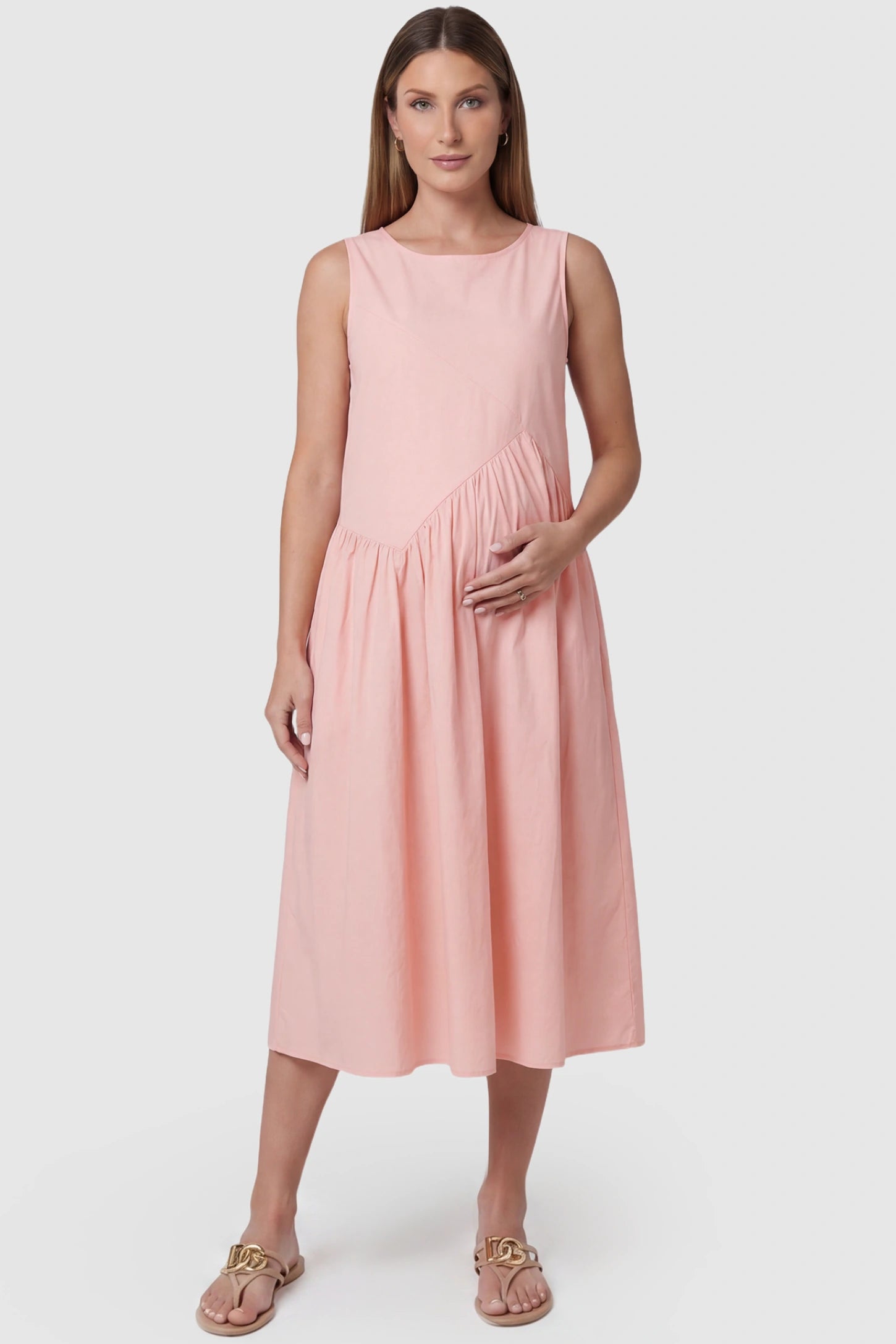 Sleeveless A-Line Maternity Midi Dress with Pockets Sleeveless A-line maternity midi dress with pockets in pink with sleeveless design and soft drape, front view on pregnant model