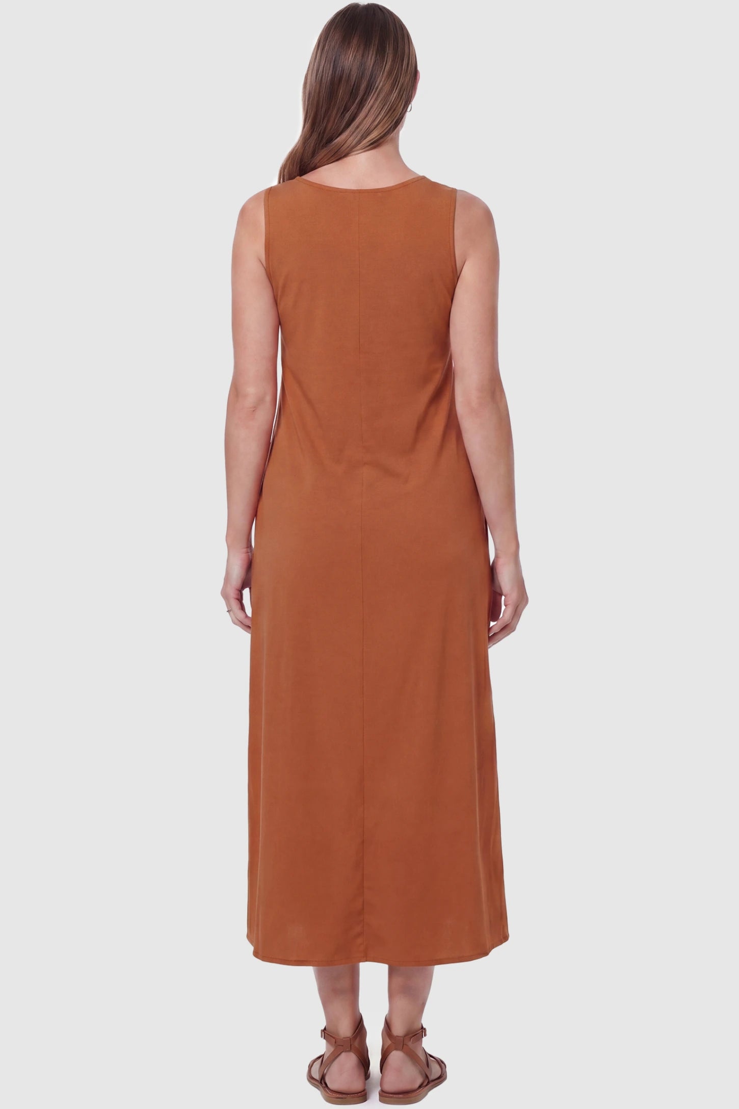 Sleeveless Pocketed Longline Hem Maternity Midi Dress Sleeveless pocketed longline hem maternity midi dress in rust brown with sleeveless design and longline hem, back view on pregnant model