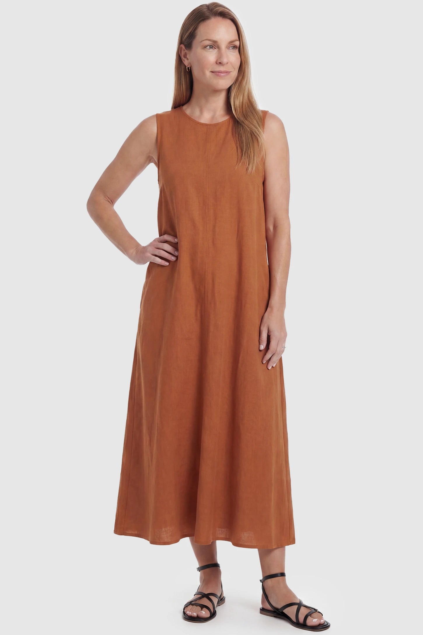 Sleeveless Pocketed Longline Hem Maternity Midi Dress Sleeveless pocketed longline hem maternity midi dress in rust brown with sleeveless design and longline hem, front view on postpartum model