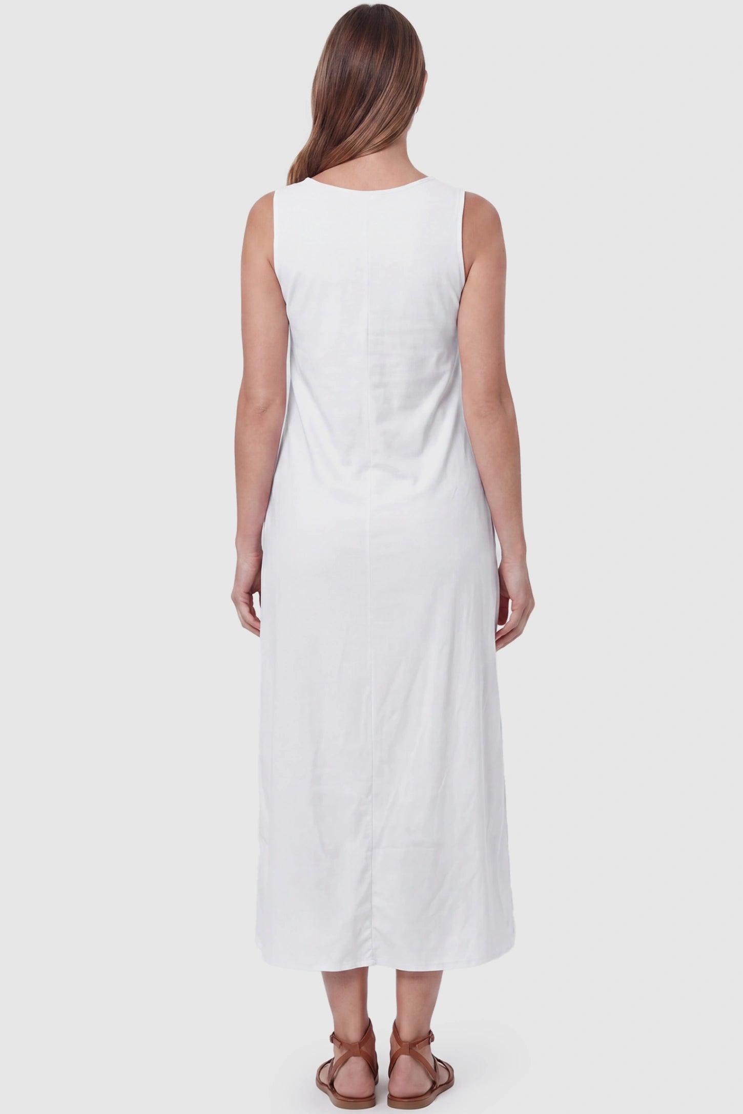 Sleeveless Pocketed Longline Hem Maternity Midi Dress Sleeveless pocketed longline hem maternity midi dress in white with sleeveless design and longline hem, back view on pregnant model