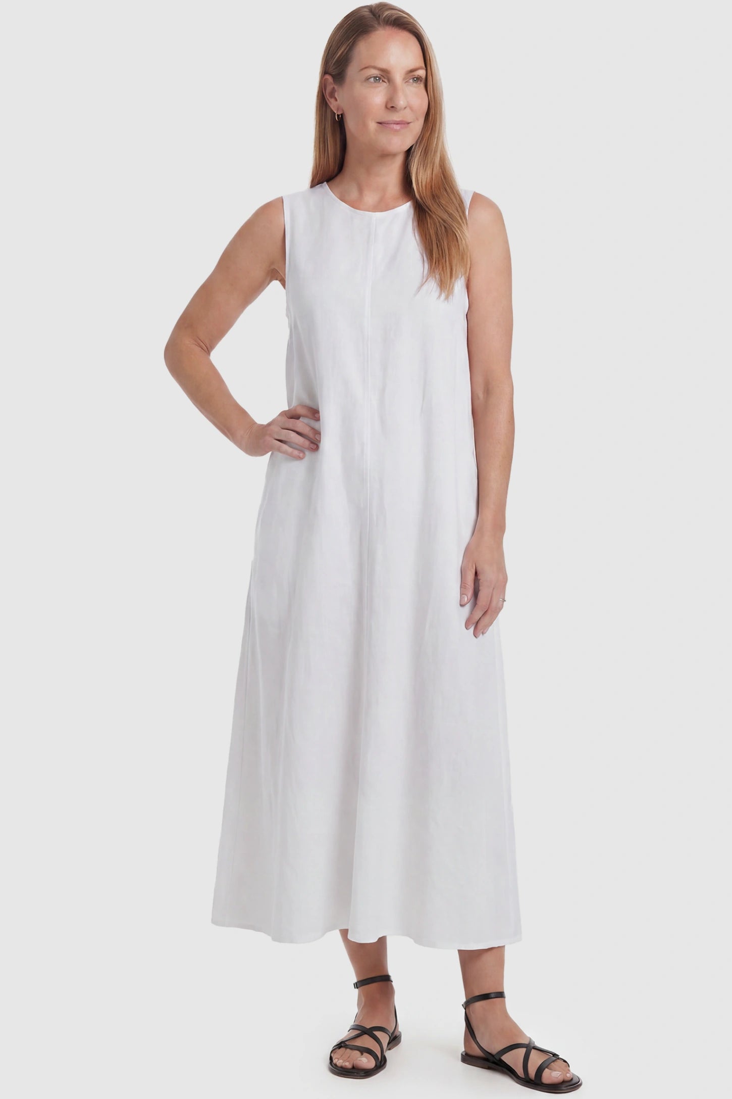 Sleeveless Pocketed Longline Hem Maternity Midi Dress Sleeveless pocketed longline hem maternity midi dress in white with sleeveless design and longline hem, front view on postpartum model