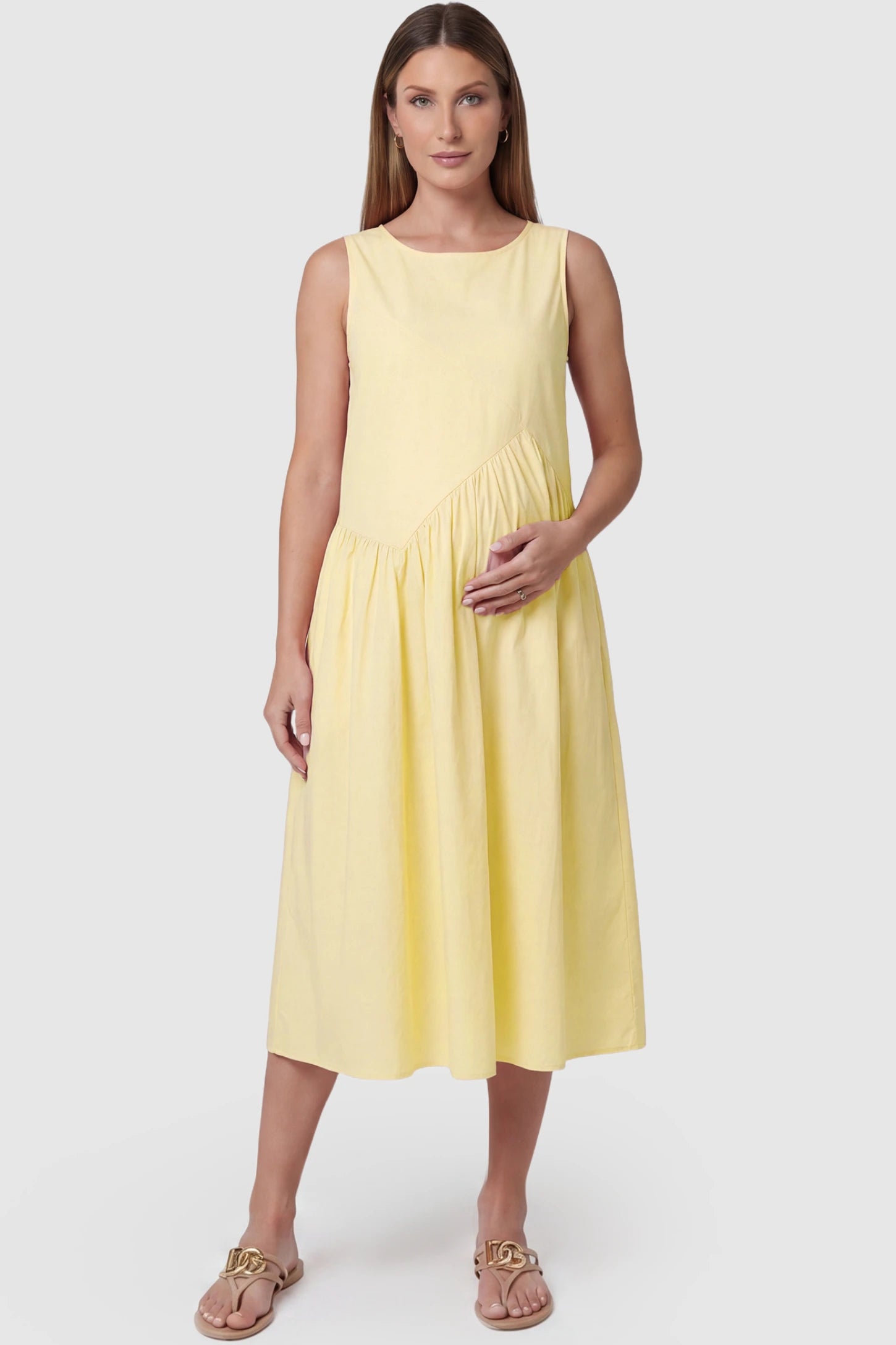 Sleeveless A-Line Maternity Midi Dress with Pockets Sleeveless A-line maternity midi dress with pockets in yellow with sleeveless design and soft drape, front view on pregnant model