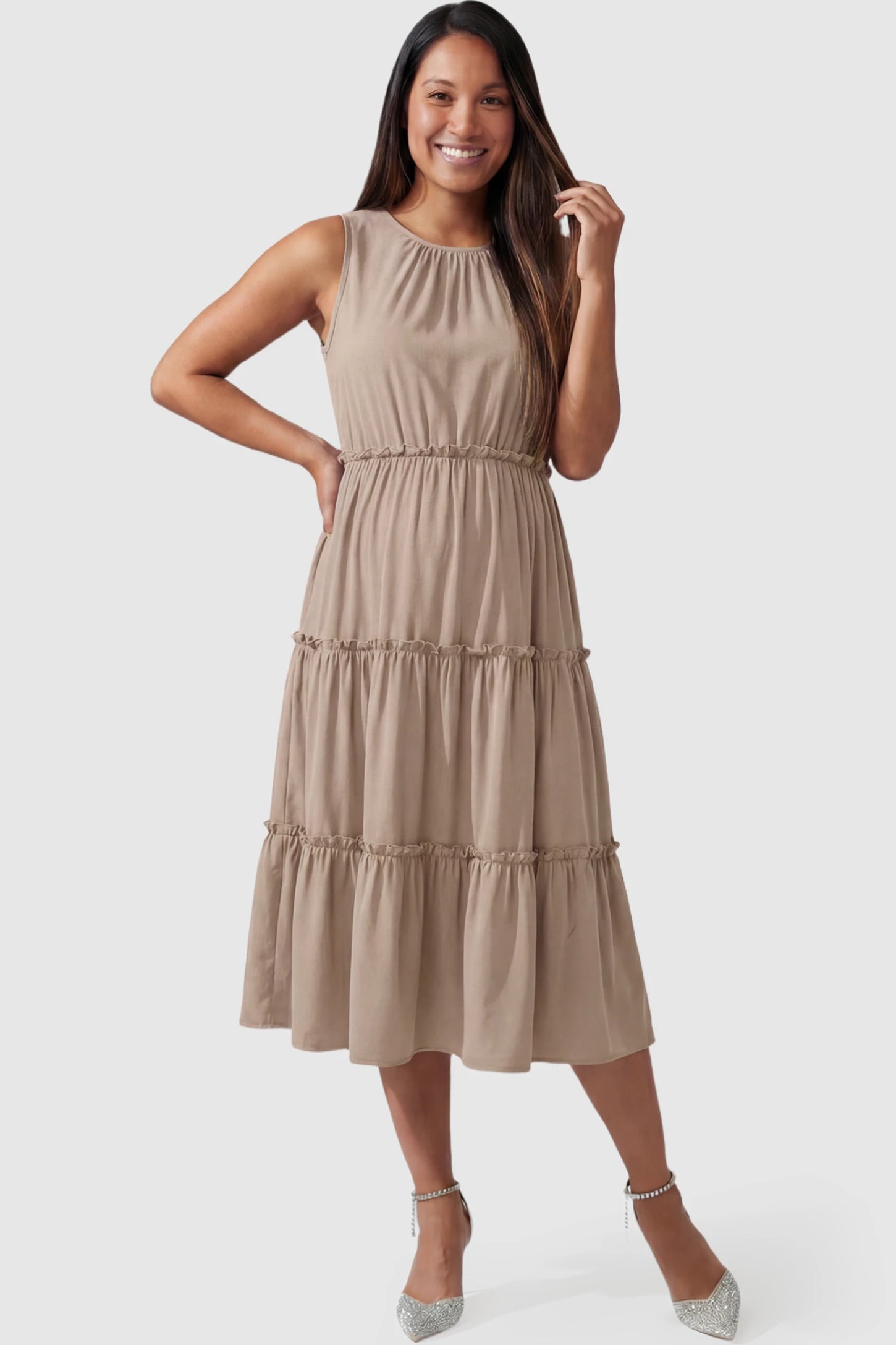 Solid Sleeveless Ruffle Tiered Maternity Midi Dress Solid Sleeveless Ruffle Tiered Maternity Midi Dress in khaki featuring a ruffle tiered skirt on a pregnant model posing front.