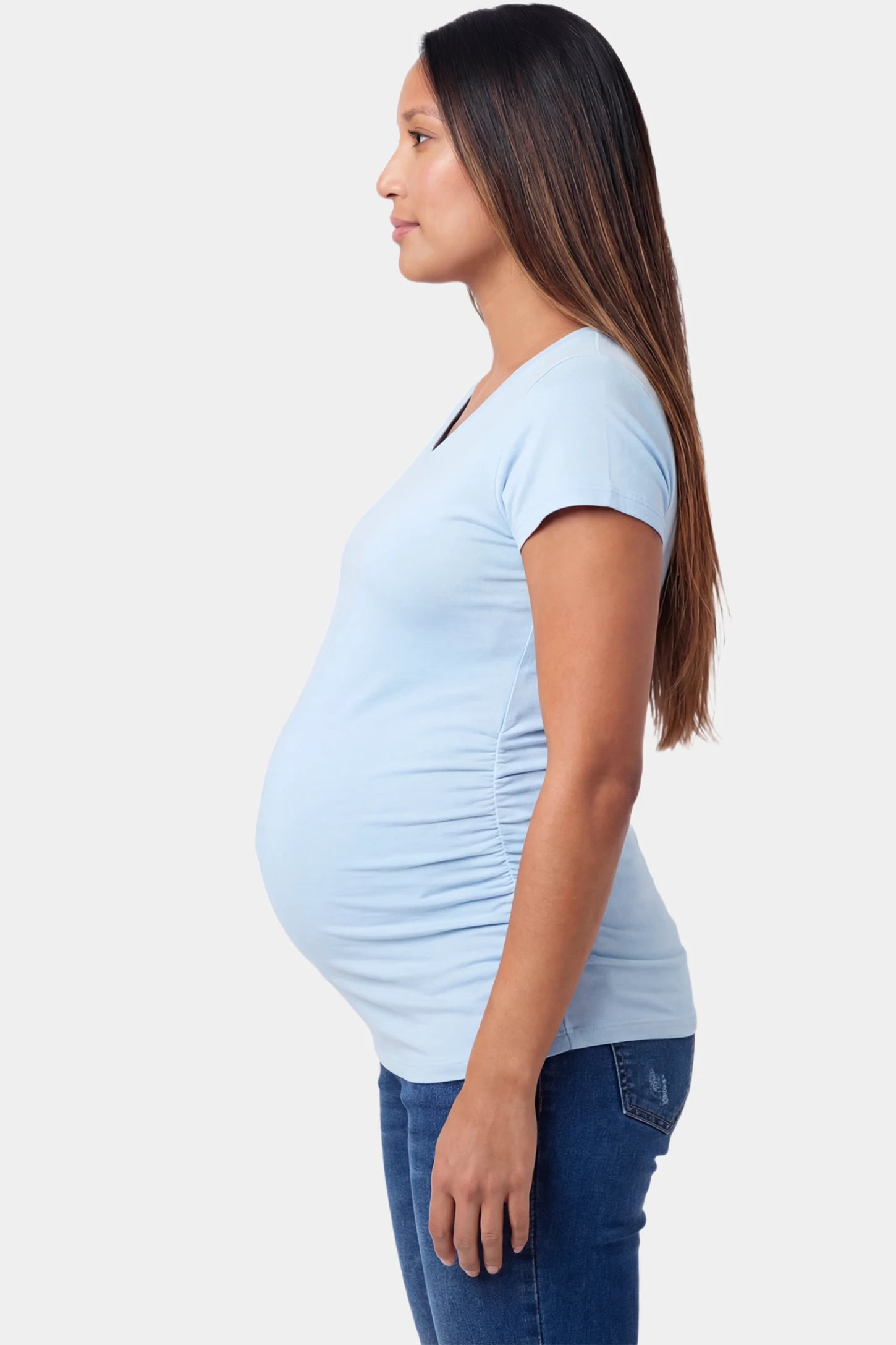 Slim fit V-neck short sleeve maternity top in light blue featuring soft stretch fabric in side view on a pregnant model
