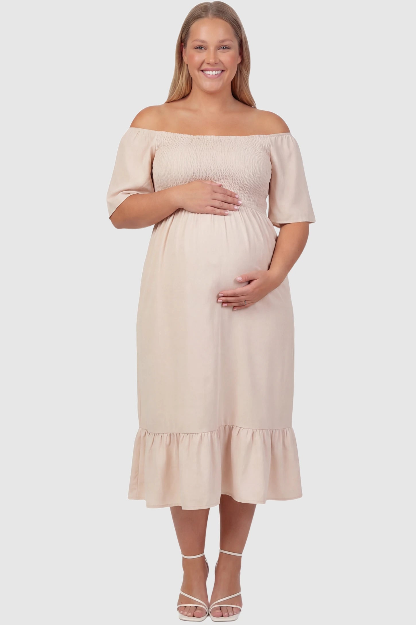 Off-Shoulder Smocked Short Sleeve A-Line Midi Maternity Dress Off-shoulder smocked short sleeve A-line midi maternity dress in apricot featuring smocked elastic waist and short sleeve in front view on a plus-size model