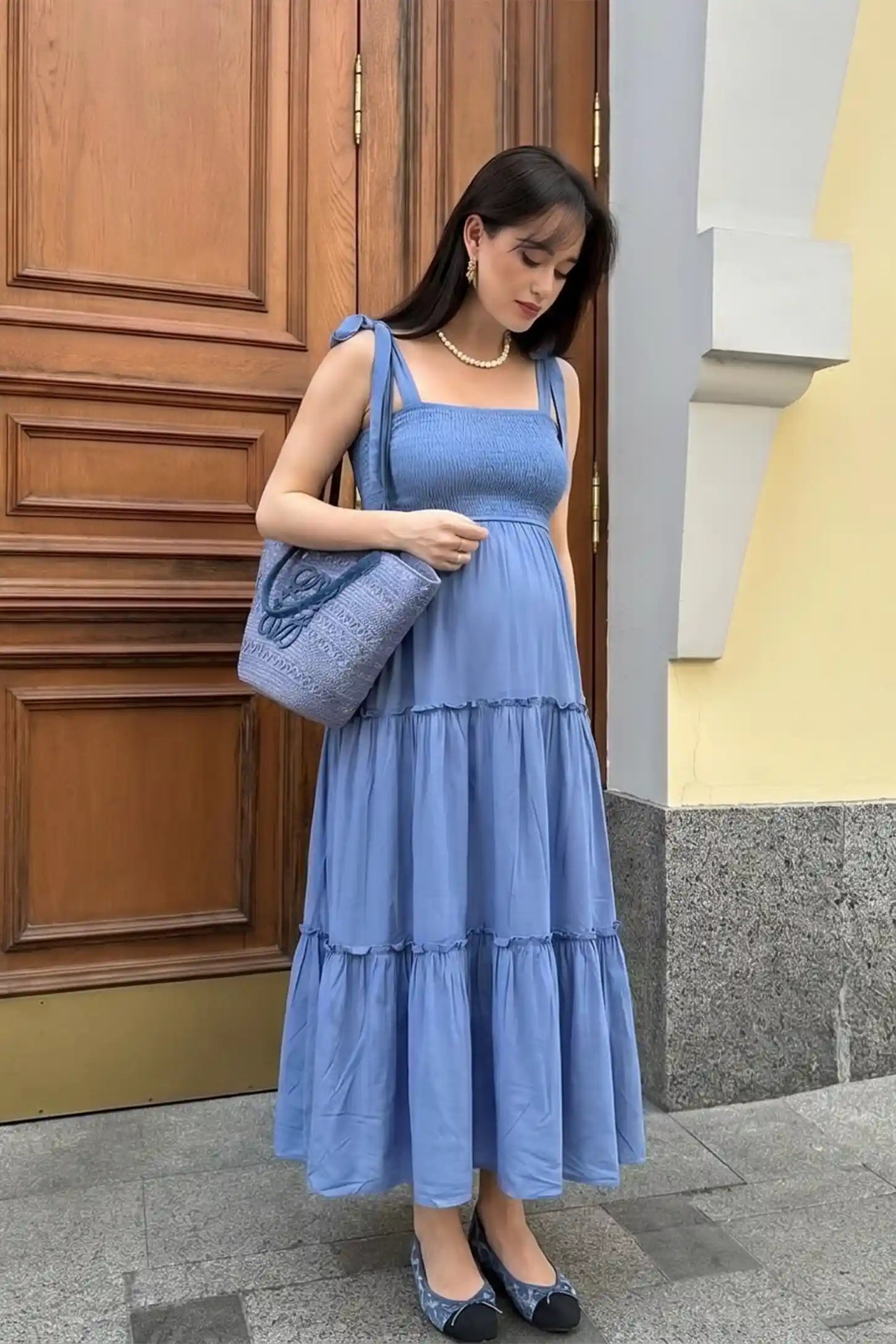 Smocked Square Neck Tiered Maternity Midi Dress Smocked square neck tiered maternity midi dress in blue with square neckline, smocked bodice, and adjustable tie straps, editorial lifestyle view