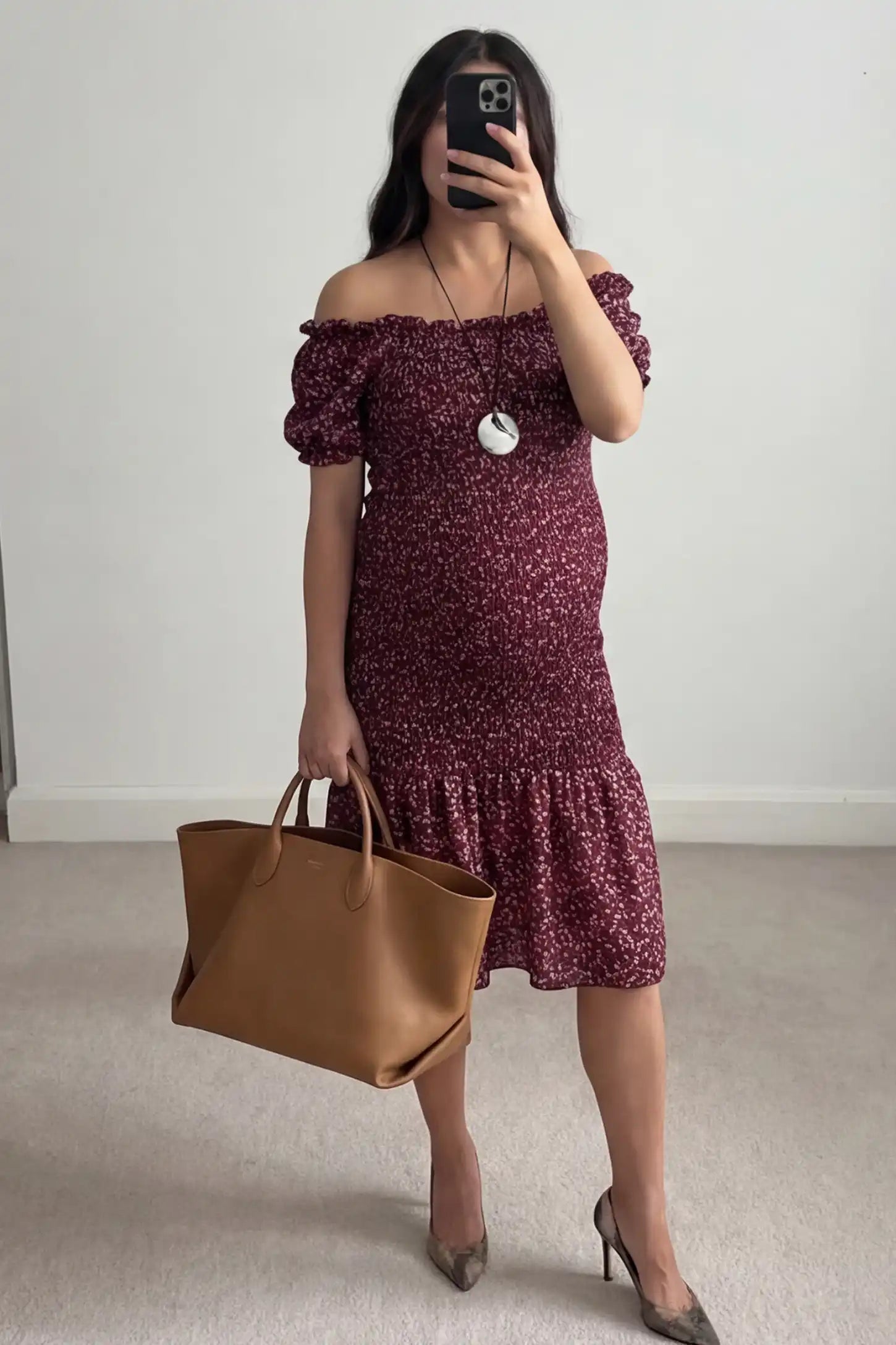 Short Puff Sleeve Smocked Maternity Midi Dress Short Puff Sleeve Smocked Maternity Midi Dress in burgundy floral featuring off shoulder neckline and ruffle hem on a pregnant model.
