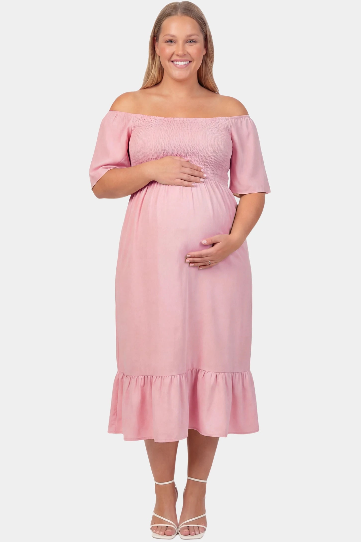 Off-Shoulder Smocked Short Sleeve A-Line Midi Maternity Dress Off-shoulder smocked short sleeve A-line midi maternity dress in pink featuring smocked elastic waist and short sleeve in front view on a plus-size model