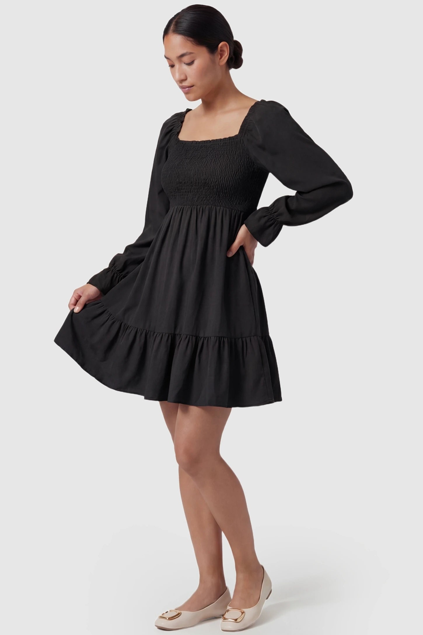 Smocked Chiffon A-Line Maternity Mini Dress Black Smocked Chiffon A-Line Maternity Mini Dress featuring a curve-hugging silhouette on a non-pregnant model, front view.
