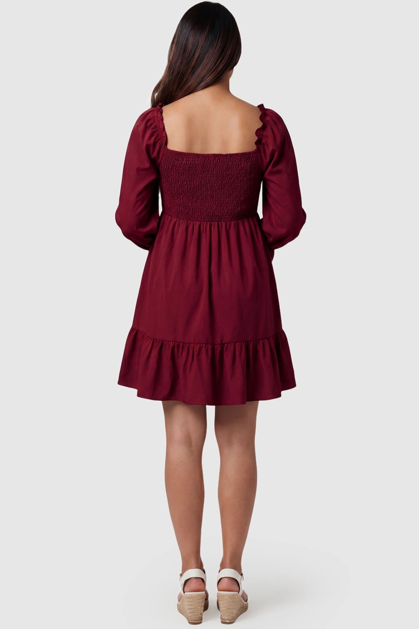 Smocked Chiffon A-Line Maternity Mini Dress Smocked Chiffon A-Line Maternity Mini Dress in Burgundy showing the full flared sleeve detail on a pregnant model, back view.