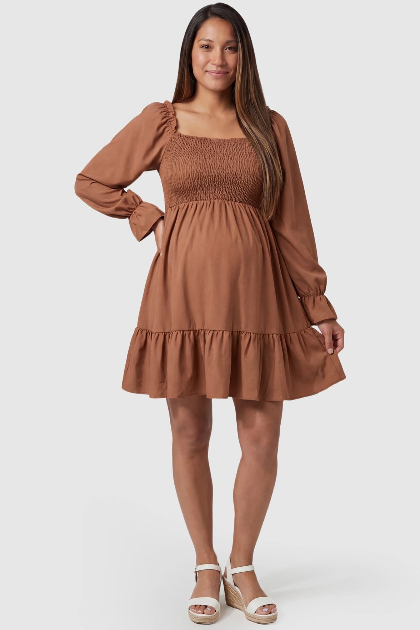 Smocked Chiffon A-Line Maternity Mini Dress Smocked Chiffon A-Line Maternity Mini Dress in Camel featuring a romantic square neckline on a pregnant model, front view.