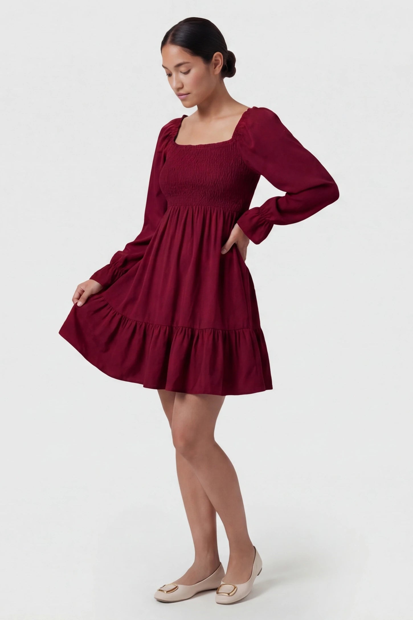 Smocked Chiffon A-Line Maternity Mini Dress Smocked Chiffon A-Line Maternity Mini Dress in Burgundy featuring a tiered skirt on a side-facing non-pregnant model.