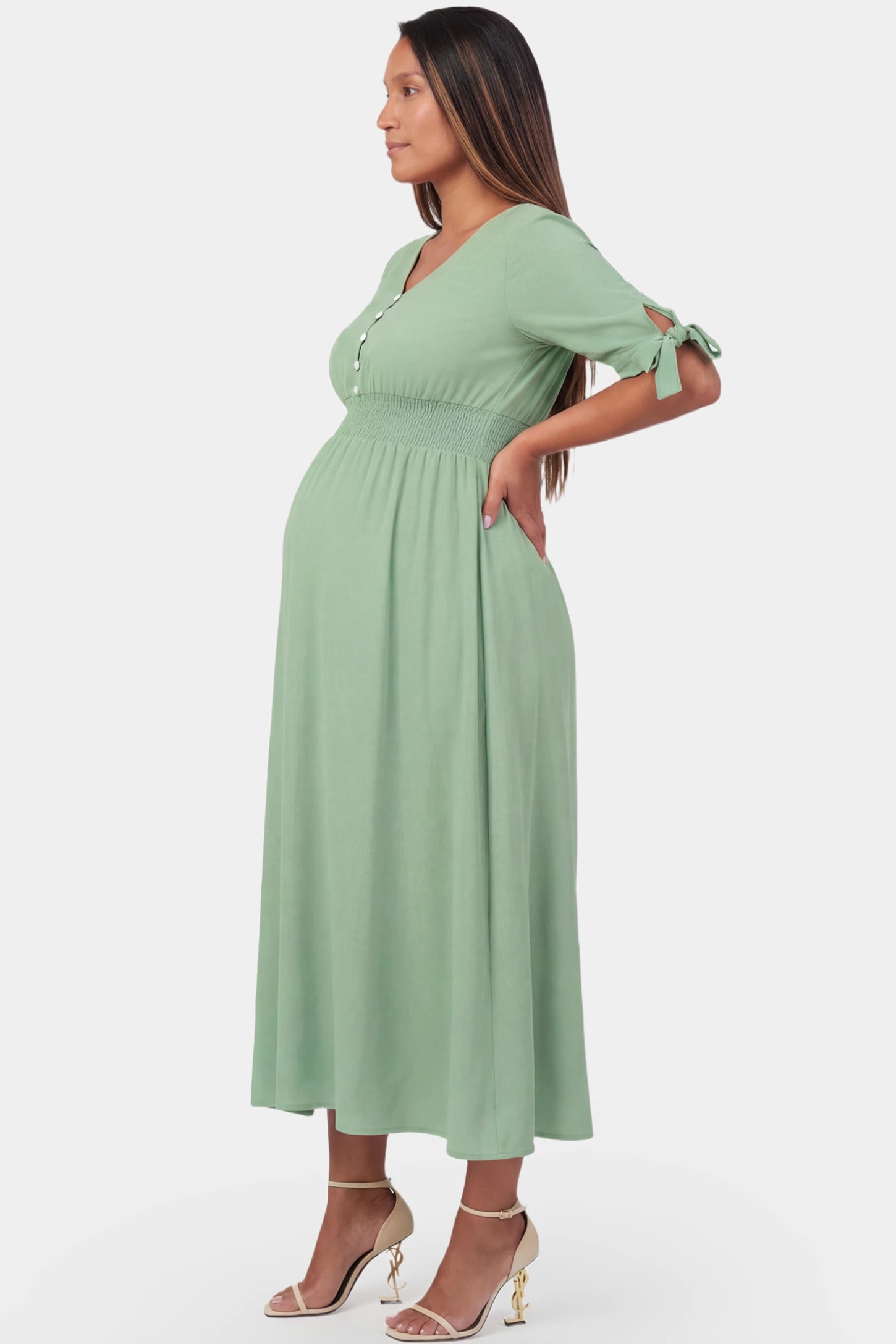 V-Neck Smocked Waist A-Line Maxi Maternity Dress V-neck smocked waist A-line maxi maternity dress in mint green featuring smocked high waist in side view on a pregnant model