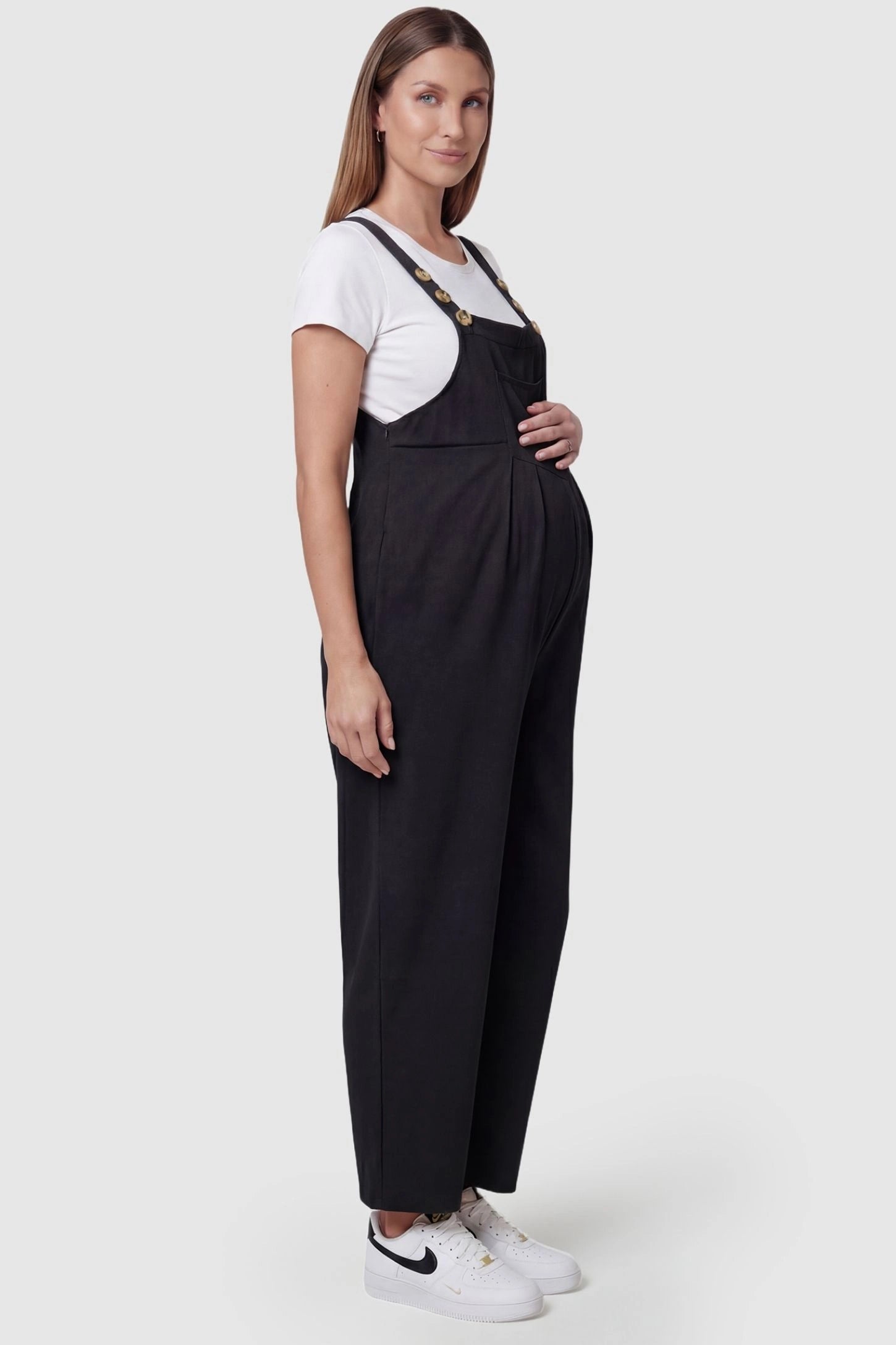 Full-Length Pocketed Maternity Jumpsuit Full-Length Pocketed Maternity Jumpsuit in Black featuring adjustable straps and a relaxed fit on a pregnant model, side view.