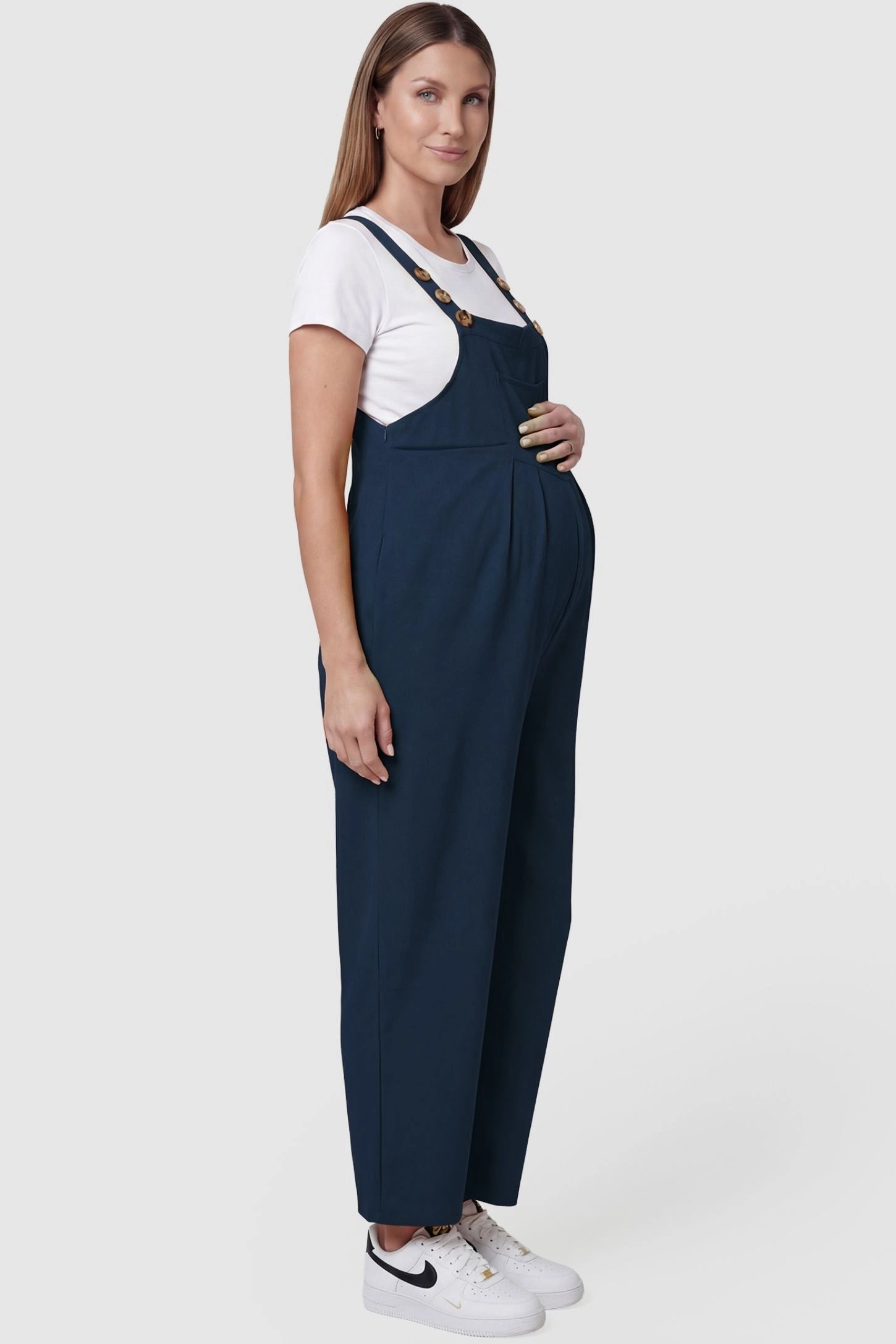 Full-Length Pocketed Maternity Jumpsuit Full-Length Pocketed Maternity Jumpsuit in Dark Blue featuring adjustable straps and a relaxed fit on a pregnant model, side view.