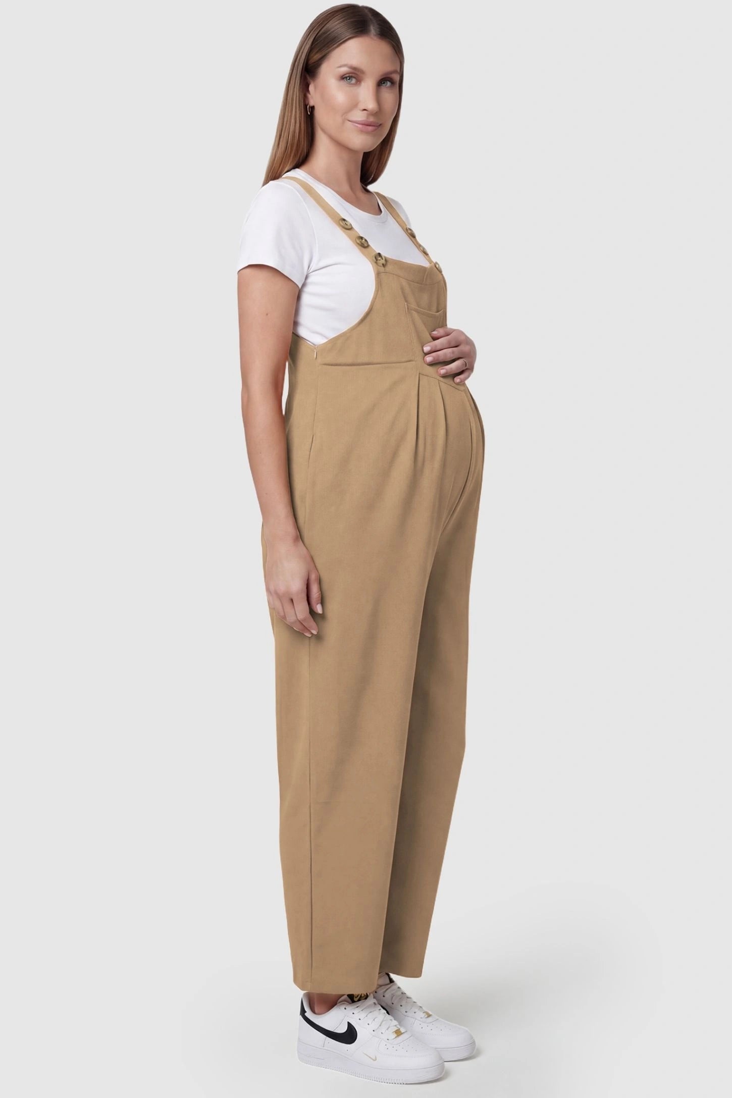 Full-Length Pocketed Maternity Jumpsuit Full-Length Pocketed Maternity Jumpsuit in Khaki featuring adjustable straps and a relaxed fit on a pregnant model, side view.