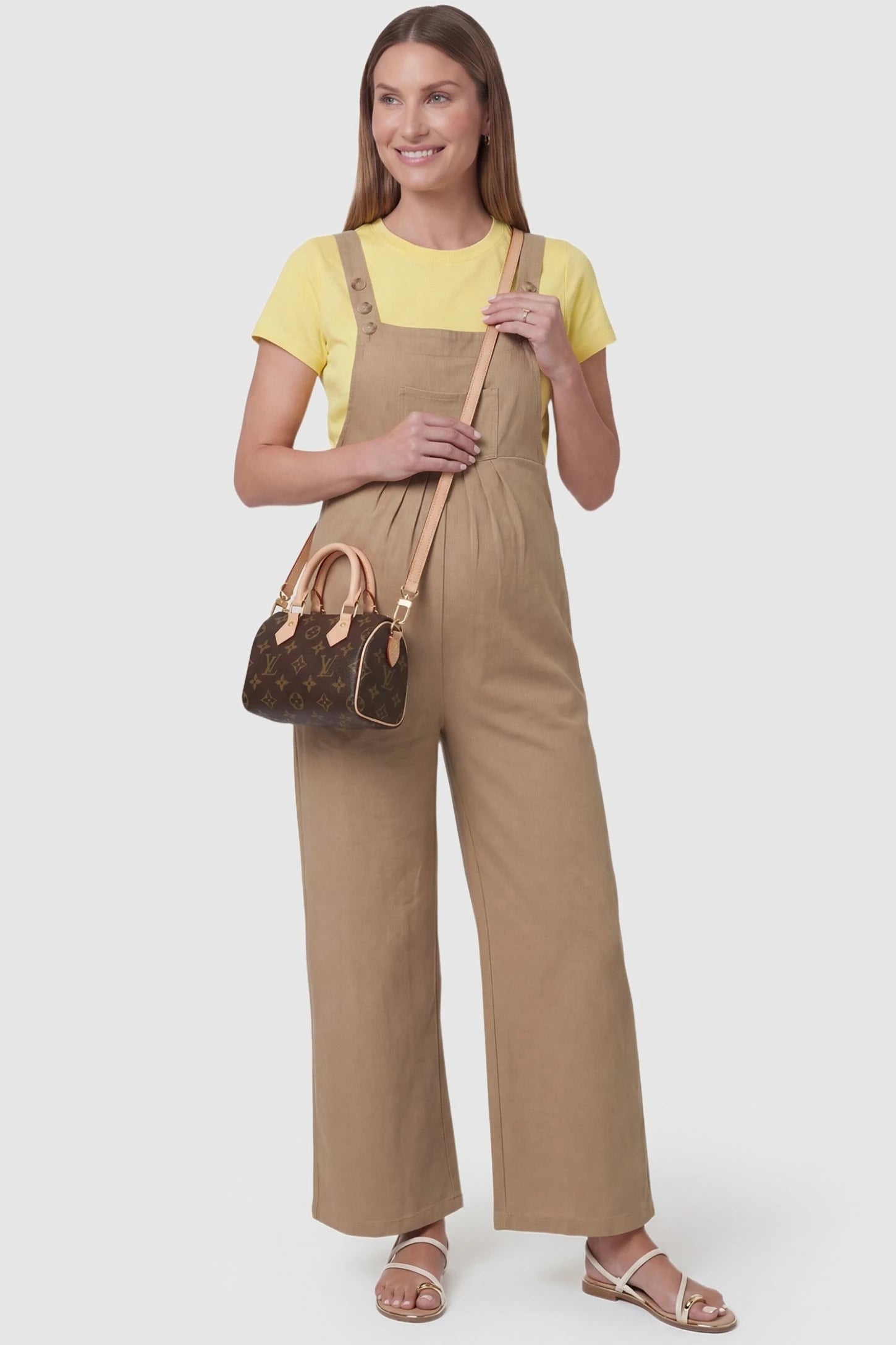 Full-Length Pocketed Maternity Jumpsuit Full-Length Pocketed Maternity Jumpsuit in Khaki featuring adjustable straps and a relaxed fit on a pregnant model, front view.