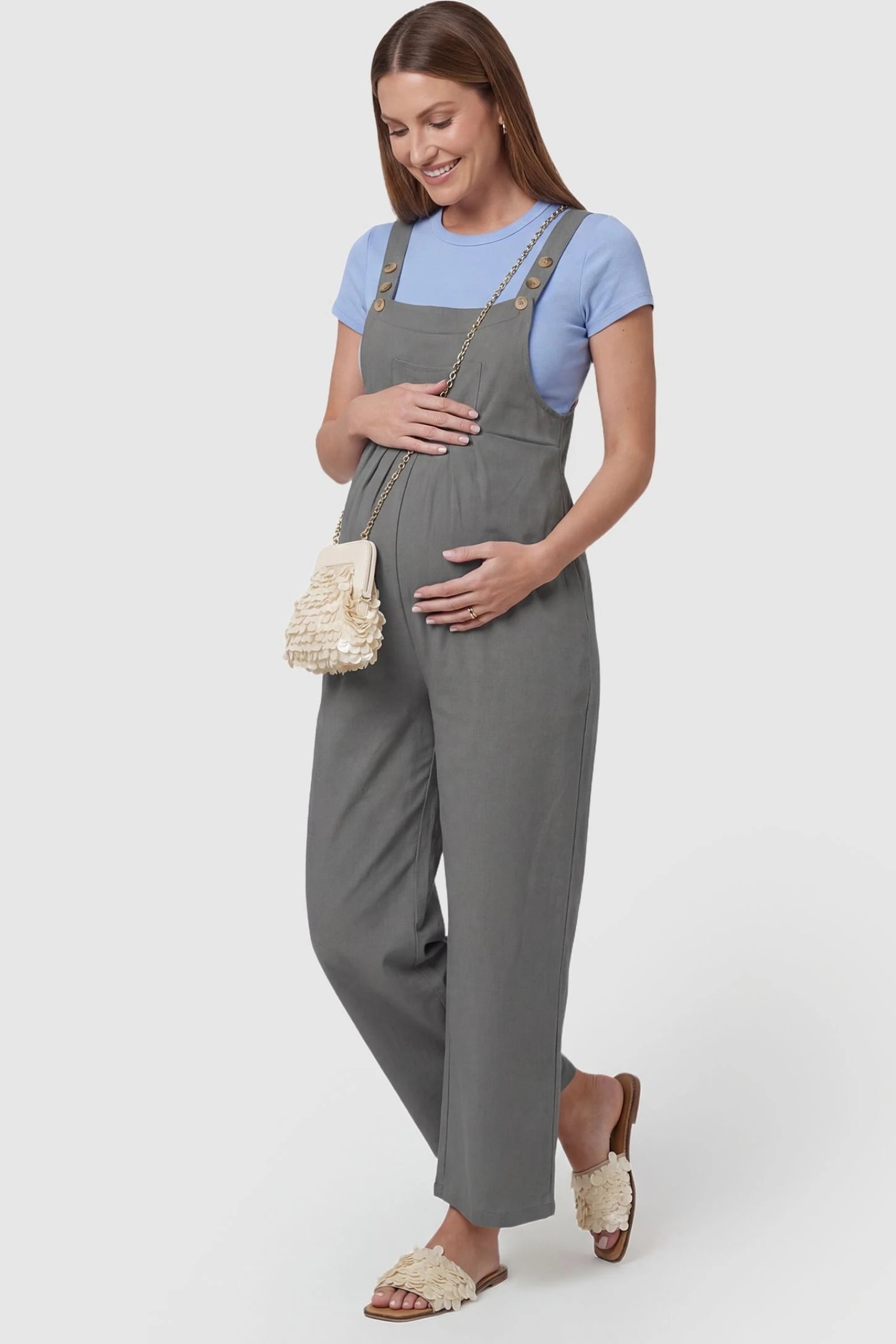 Full-Length Pocketed Maternity Jumpsuit Full-Length Pocketed Maternity Jumpsuit in Light Gray featuring adjustable straps and a relaxed fit on a pregnant model, side view.