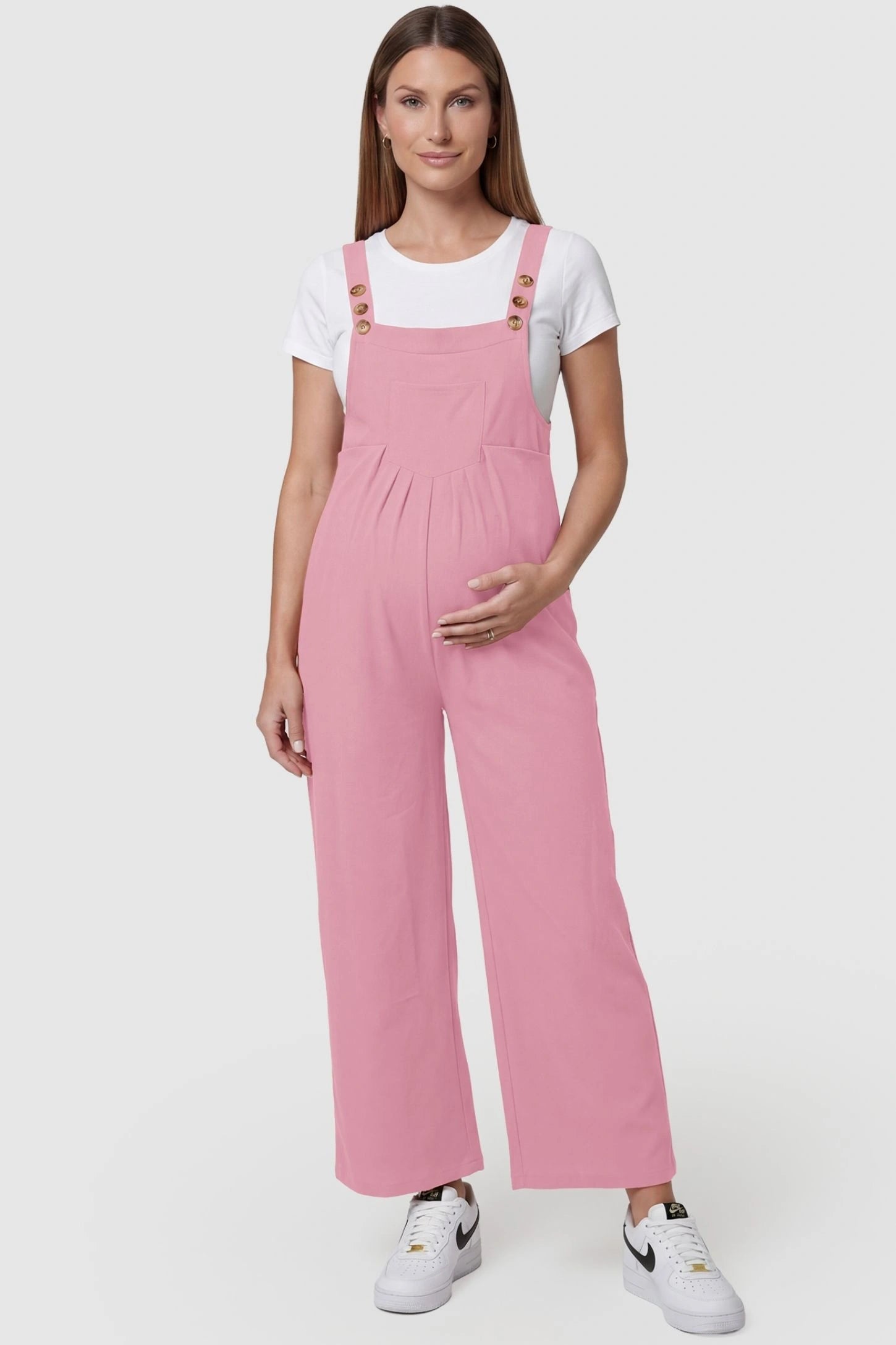 Full-Length Pocketed Maternity Jumpsuit Full-Length Pocketed Maternity Jumpsuit in Pink featuring adjustable straps and a relaxed fit on a pregnant model, front view.