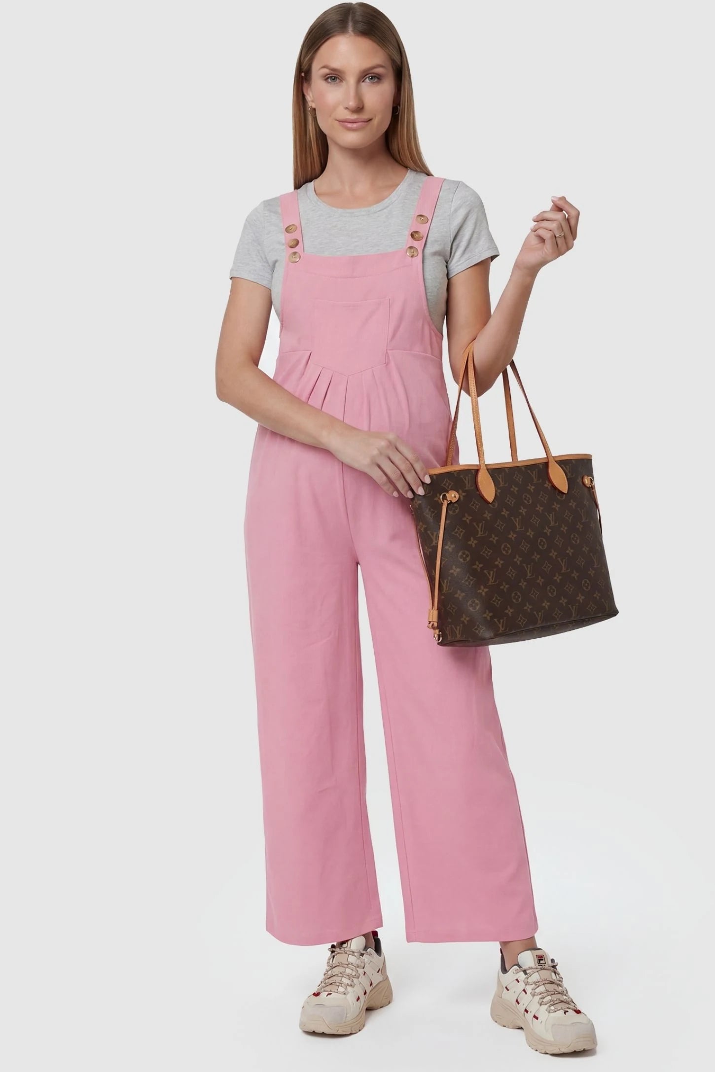 Full-Length Pocketed Maternity Jumpsuit Full-Length Pocketed Maternity Jumpsuit in Pink featuring adjustable straps and a relaxed fit on a pregnant model, front view.